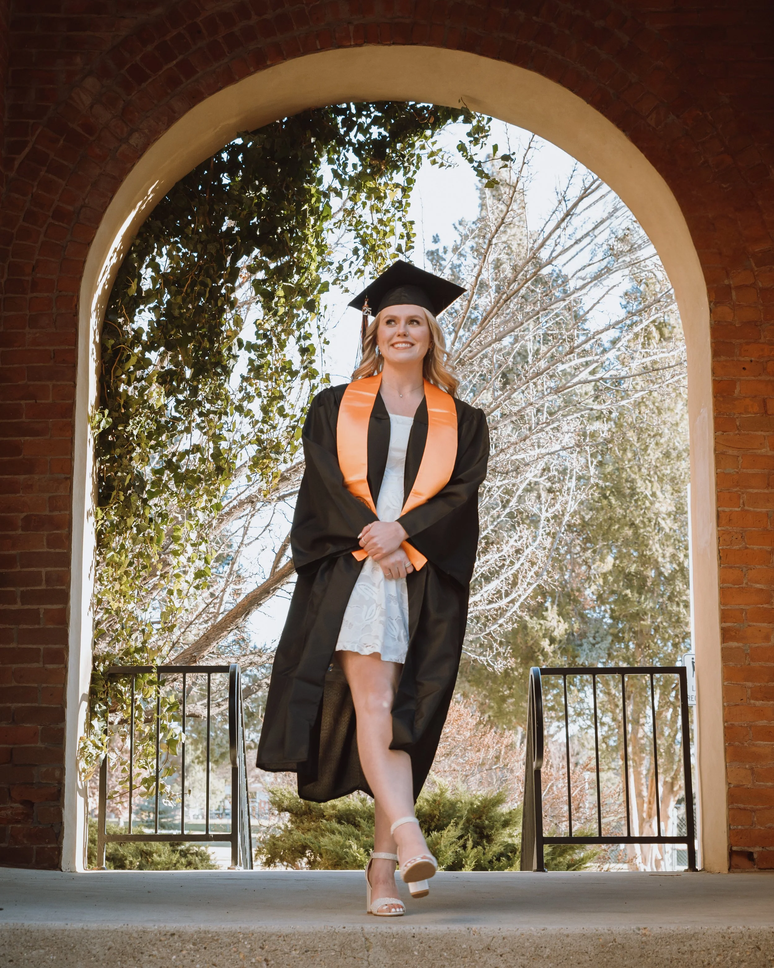 women at the arch at idaho state university getting a graduation photoshoot done