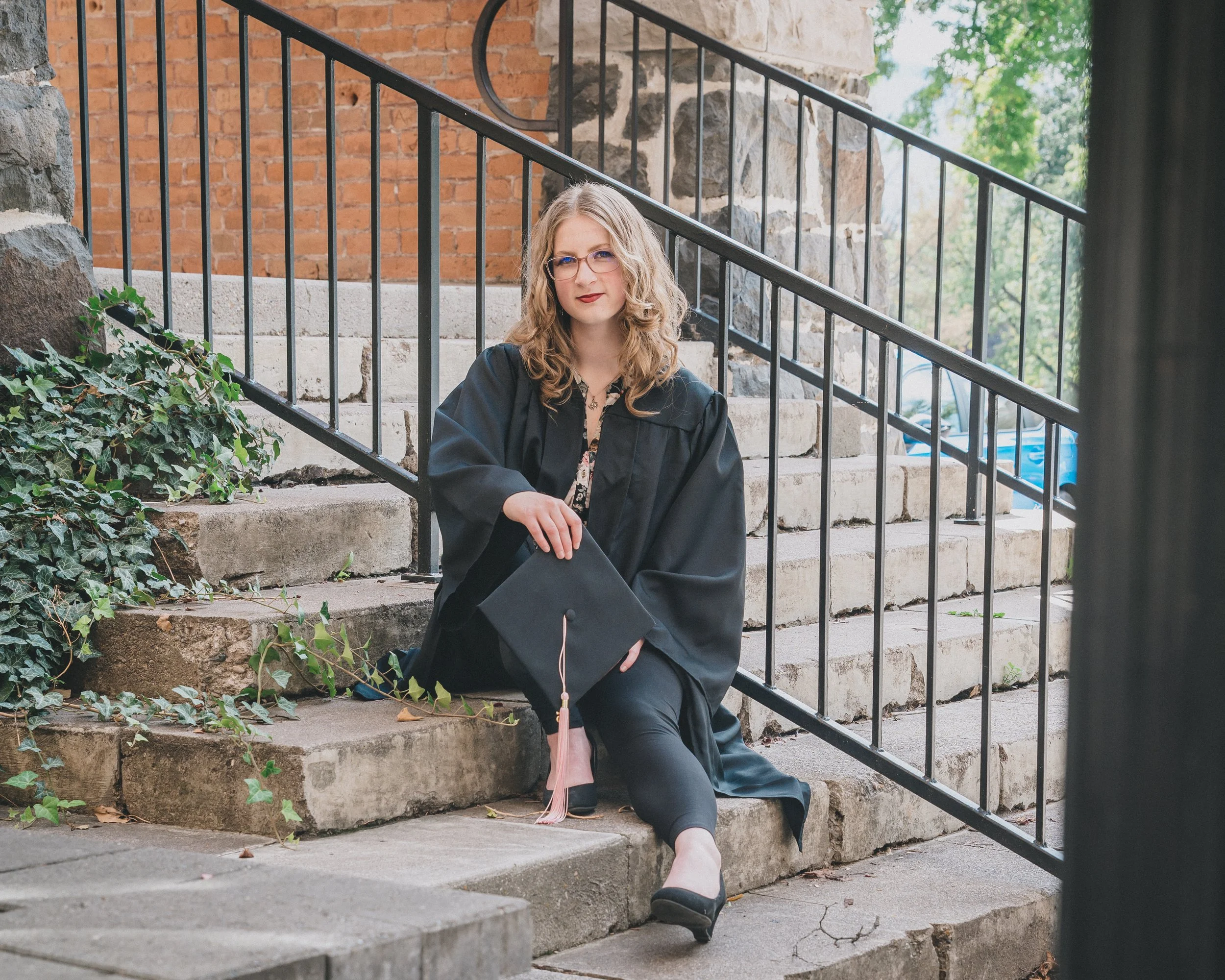 women sitting at the steps getting a graduation photoshoot done