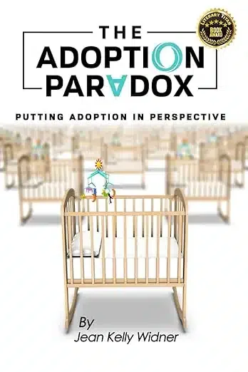 Book cover titled "The Adoption Paradox" by Jean Kelly Widner, with a subtitle "Putting Adoption in Perspective," featuring a wooden crib in a nursery with a slightly blurred background of a waiting room or hospital environment.
