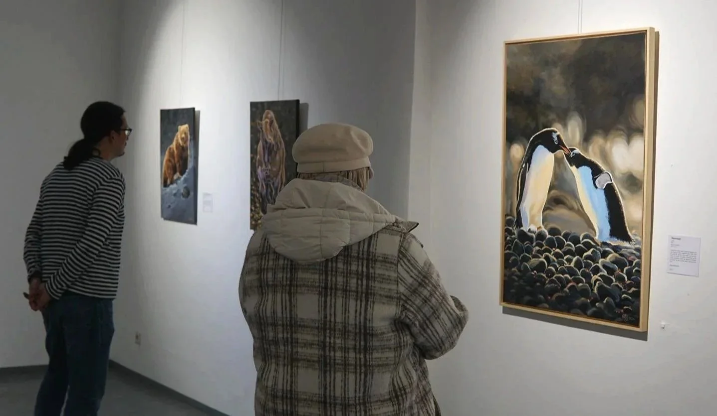 Zwei Besucher betrachten Acrylgemälde mit Tiermotiven in der Ausstellung „Die Kraft der Natur“ in der Stehbach-Galerie Mayen.