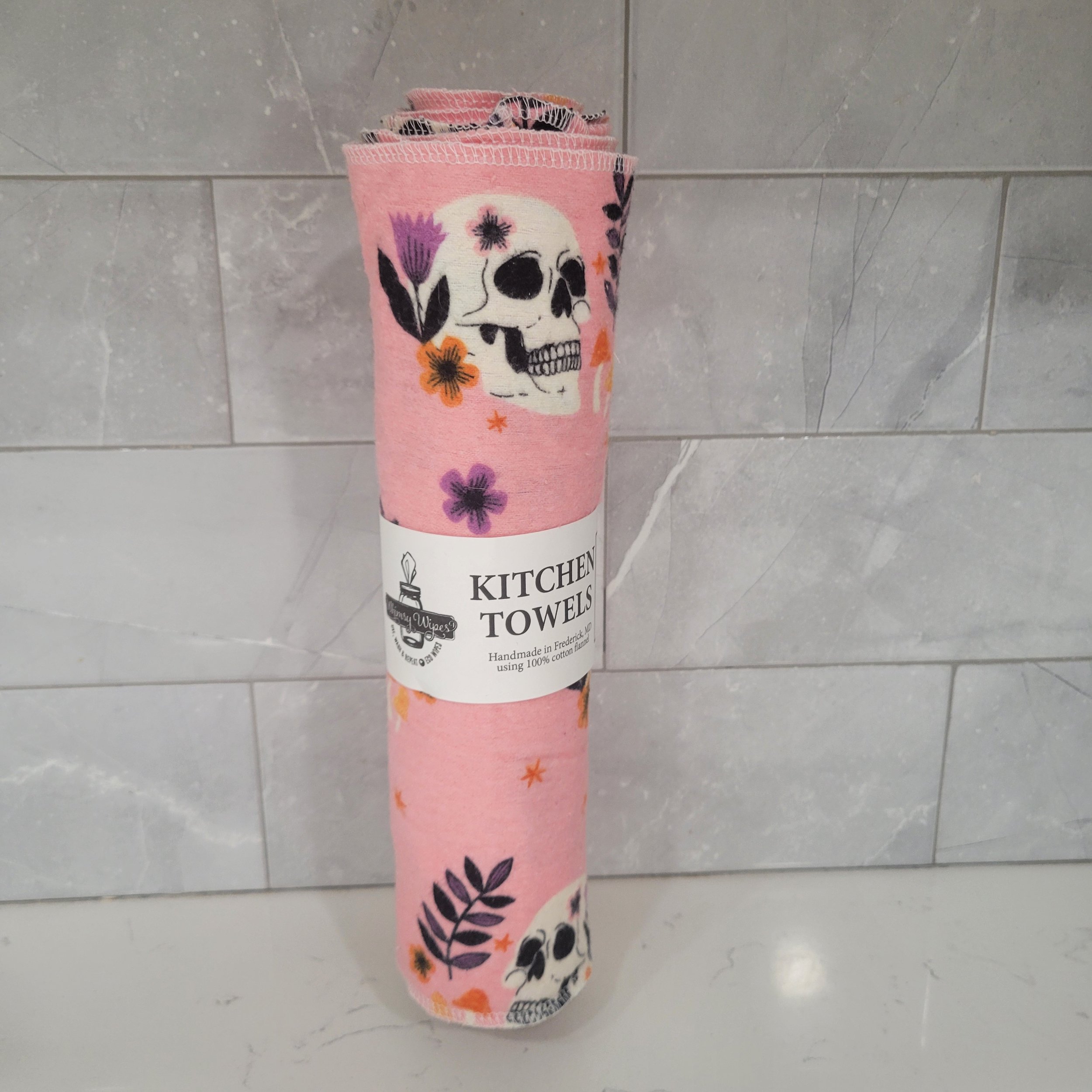 Reusable kitchen towels showing skulls amongst ferns with a bubblegum pink background
