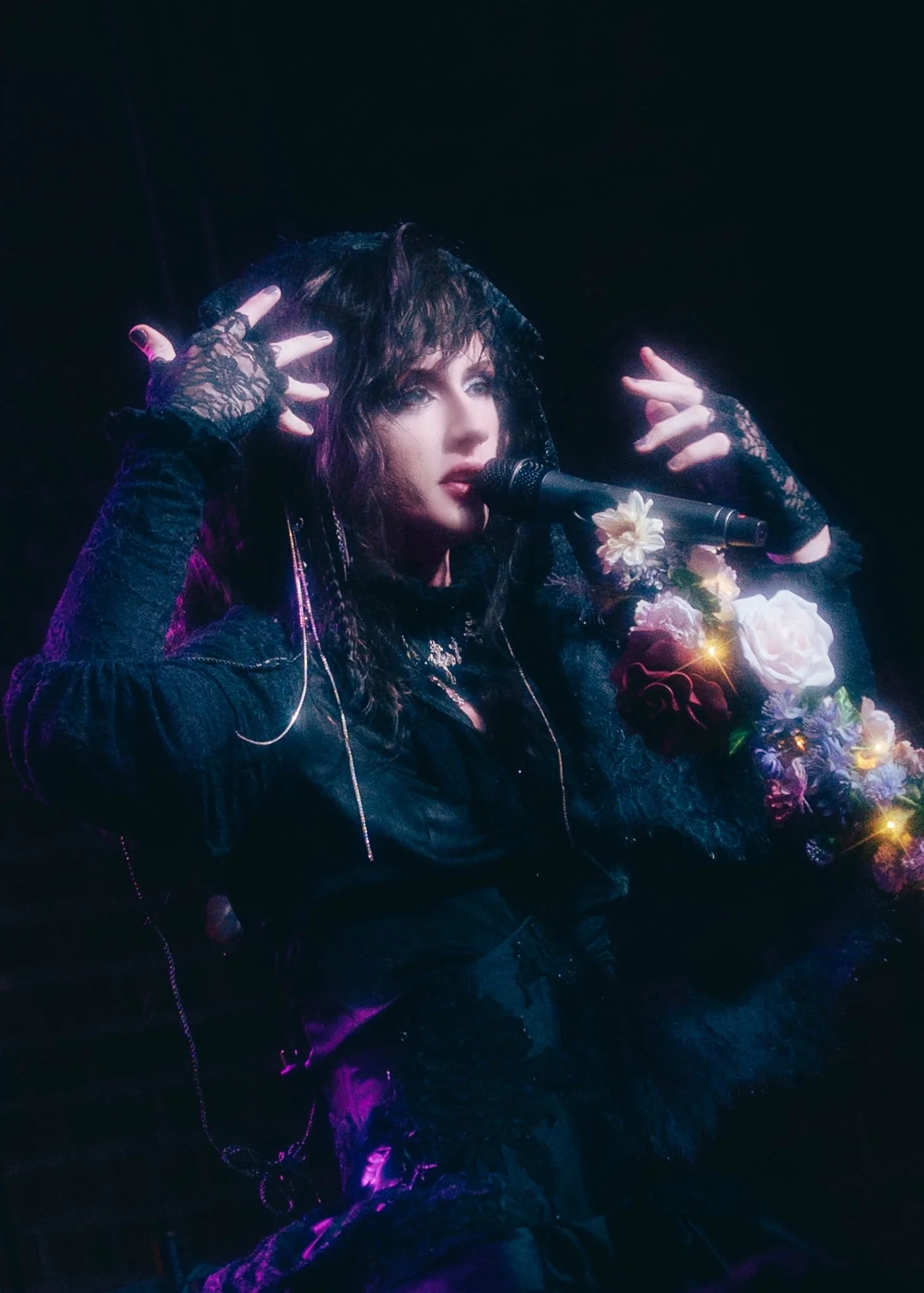 Canary Kasey dramatically performing on stage with visual kei makeup.