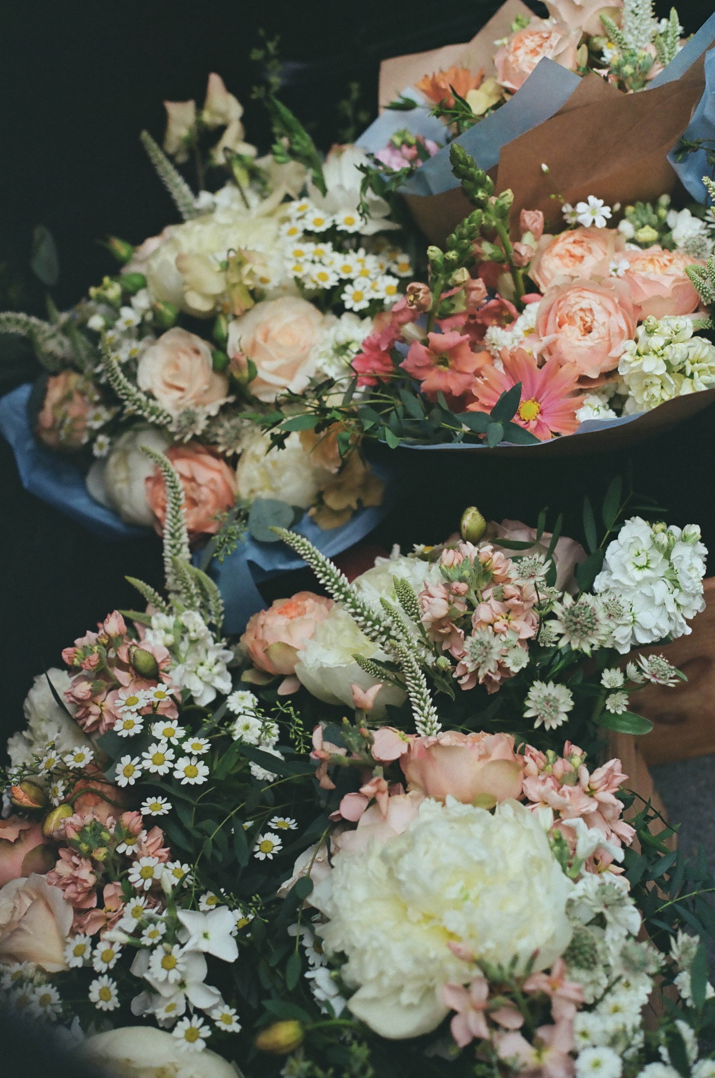 Various flower bouquets with peonies, daisies, and other mixed flowers in soft pastel colors.