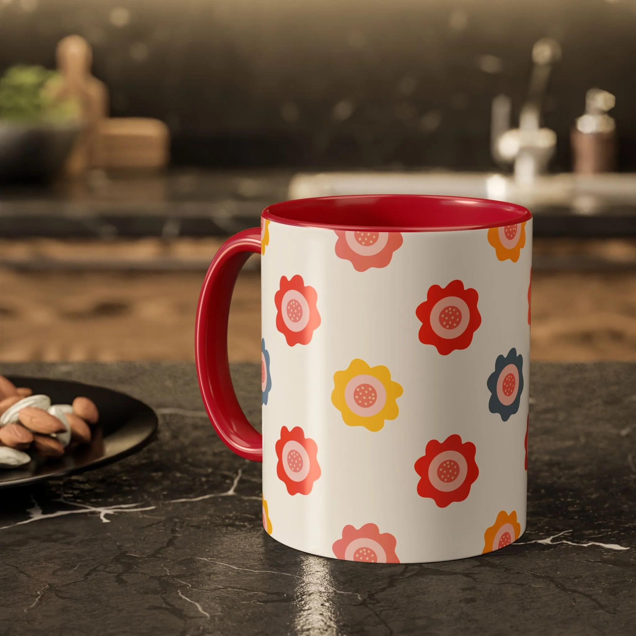 A white mug with a red handle and interior, decorated with colorful flower patterns, placed on a dark marble countertop in a kitchen setting.