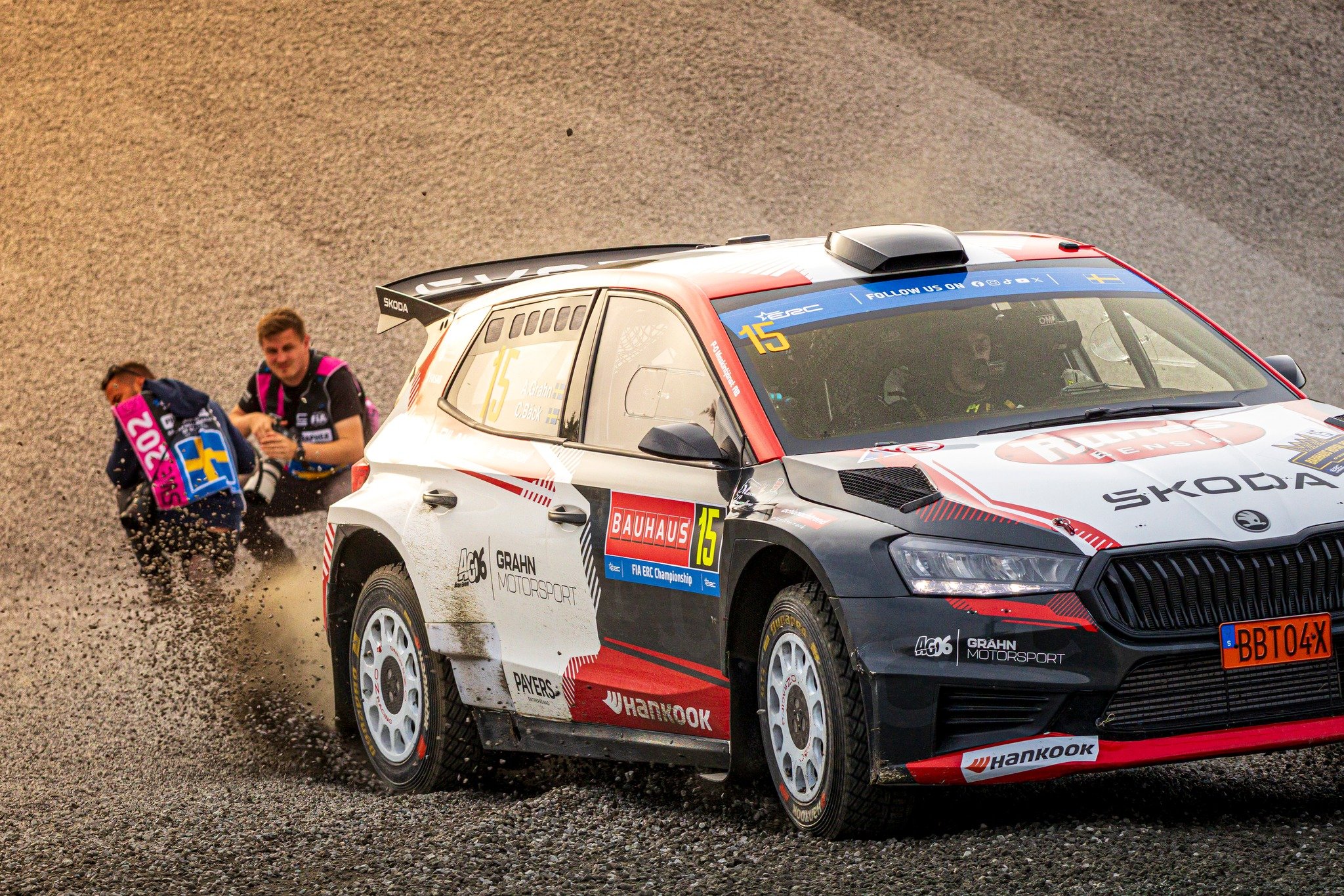 Front row seats come with consequences. 

Adam Grahn and Christoffer B&auml;ck with the &Scaron;koda Fabia RS Rally2 during ERC BAUHAUS Royal Rally Sweden, while photographers in the background prepare for the inevitable dust shower.

📸 Marco Rimola