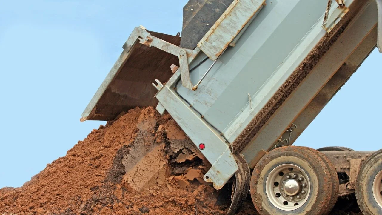 Dump truck unloading dirt on the ground