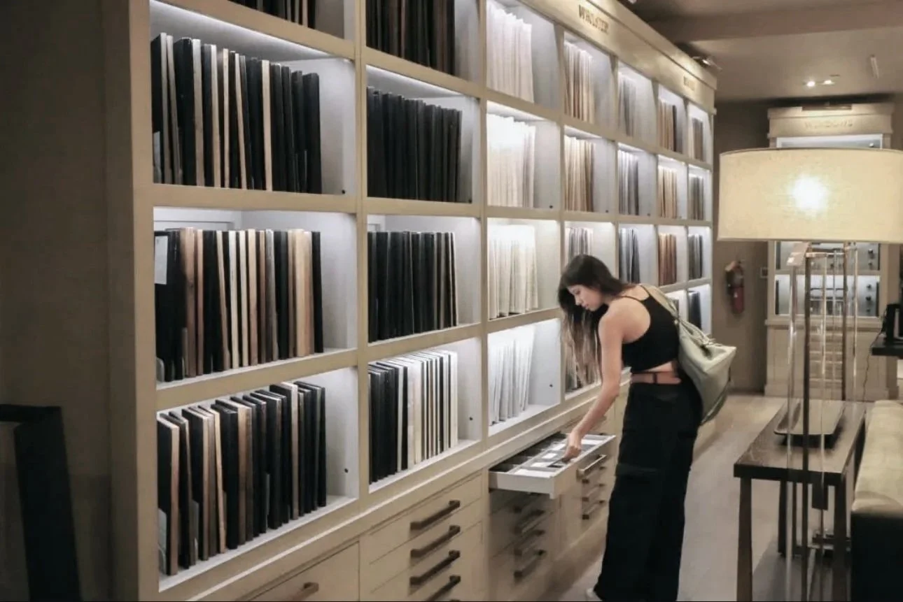 Joven mujer revisando álbumes en una librería o biblioteca.