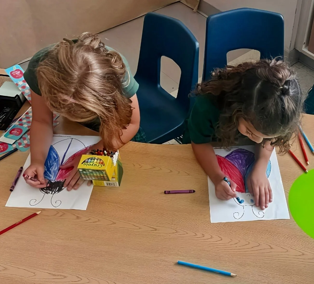 Young children coloring with crayons in classroom