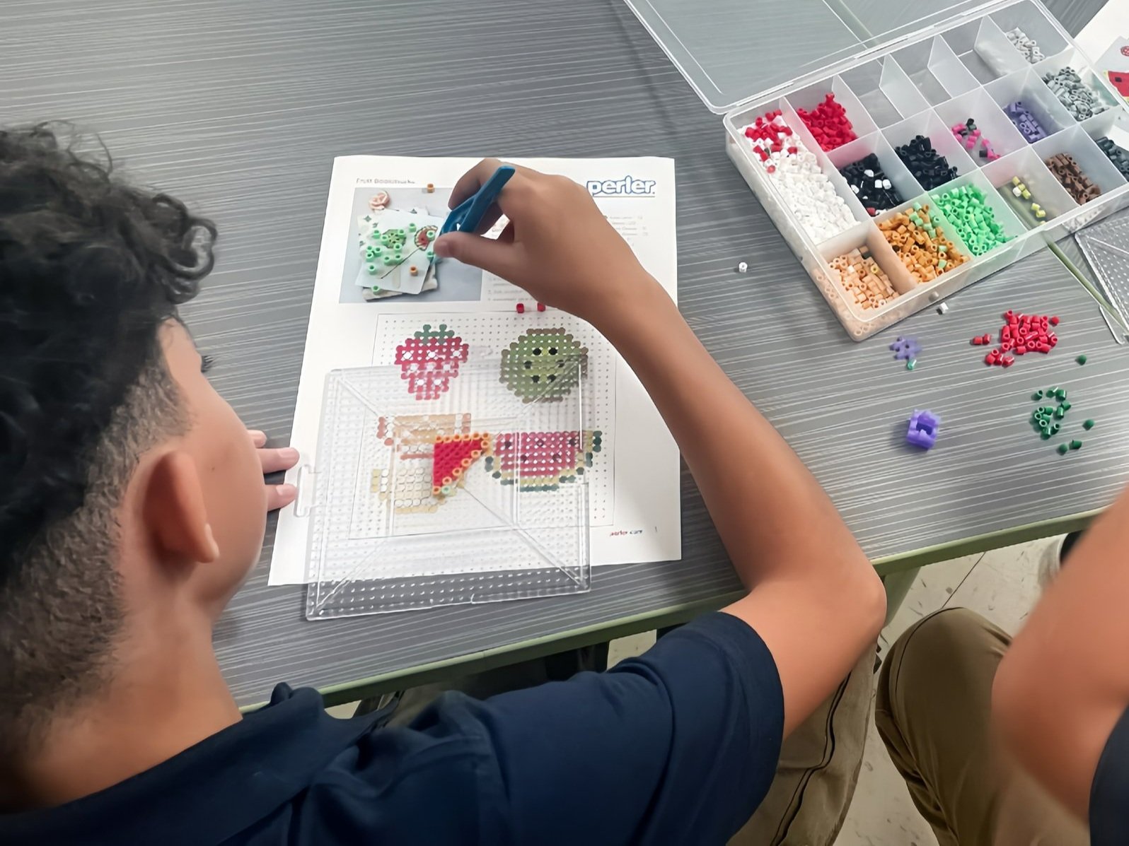 First grade student using beads for hands-on classroom project