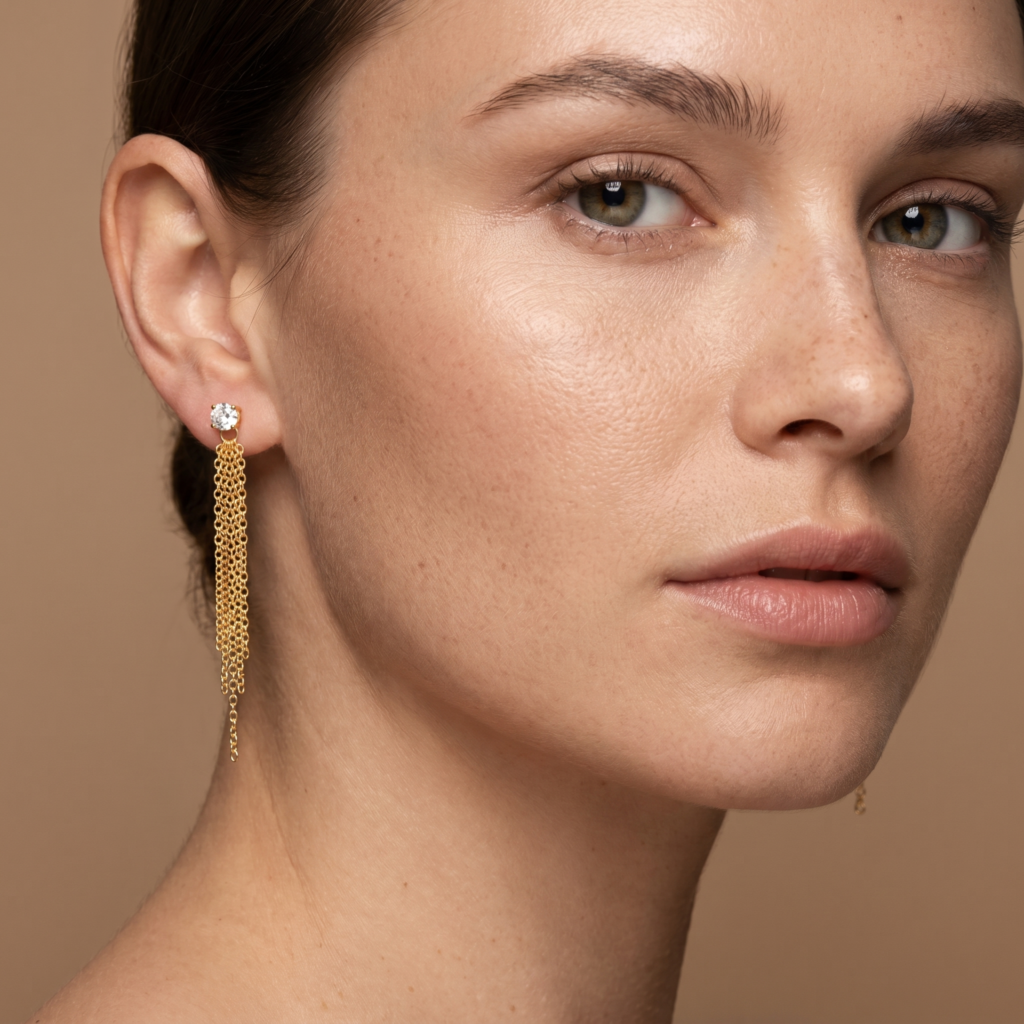 Woman wearing 18K gold plated 925 sterling silver tassel earrings with brilliant zirconia stones and cascading chain details.