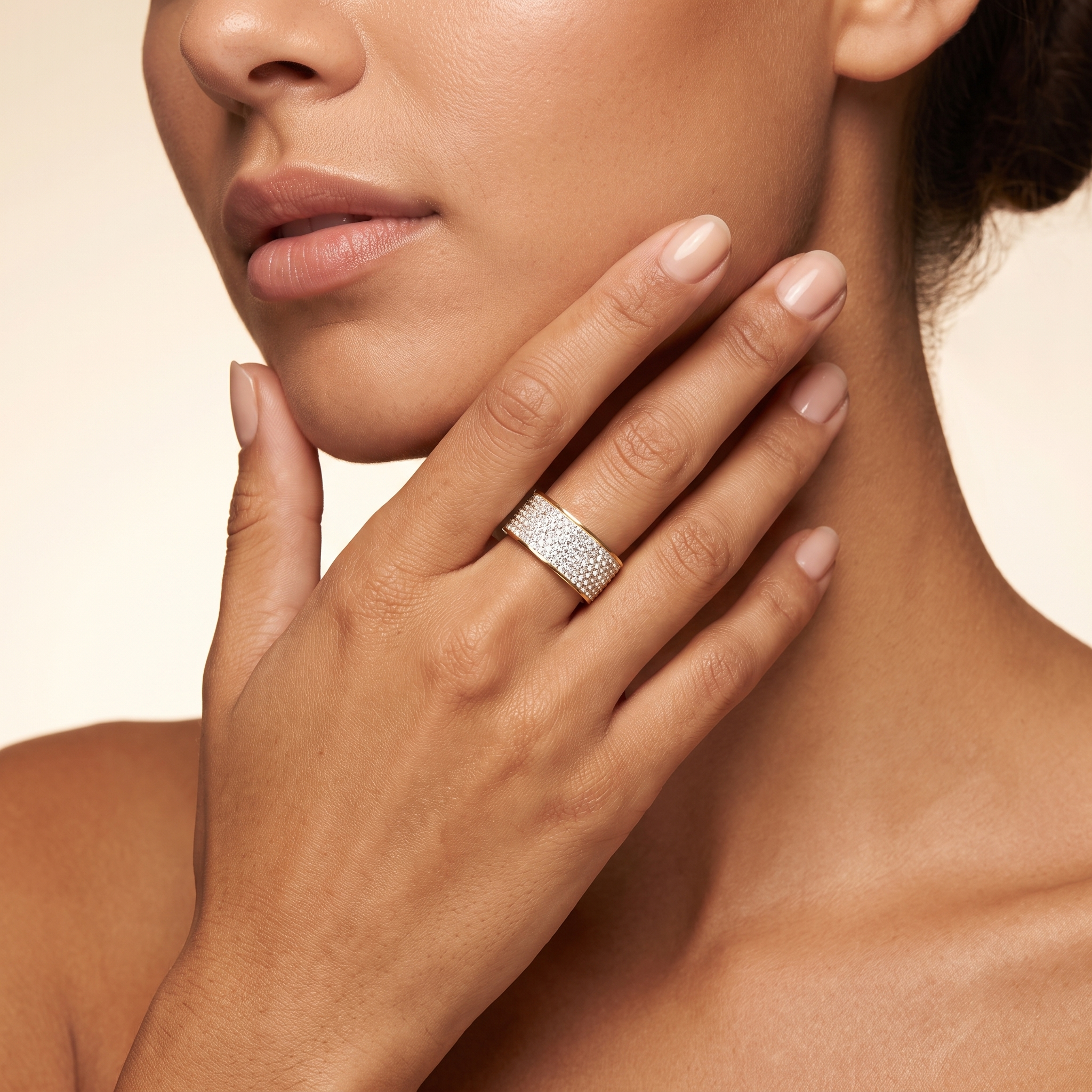 Woman wearing LAURRÈ Intensity gold pavé statement ring with clear cubic zirconia and wide PVD gold-plated band