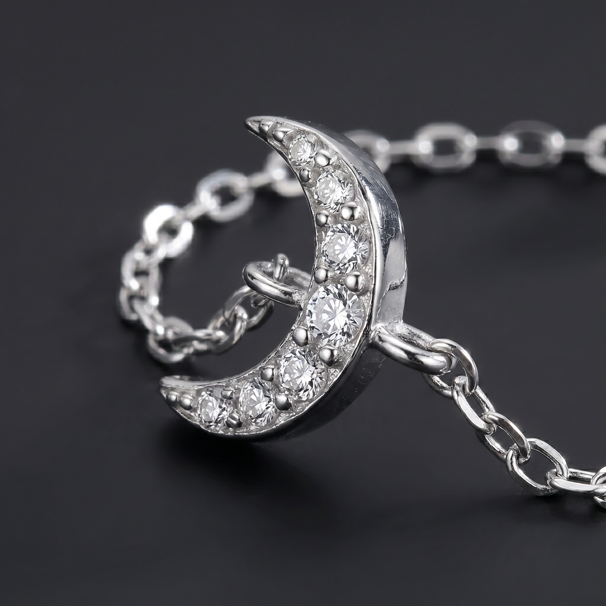 925 sterling silver crescent moon ring featuring sparkling cubic zirconia stones and an adjustable chain design, photographed in luxury macro detail.