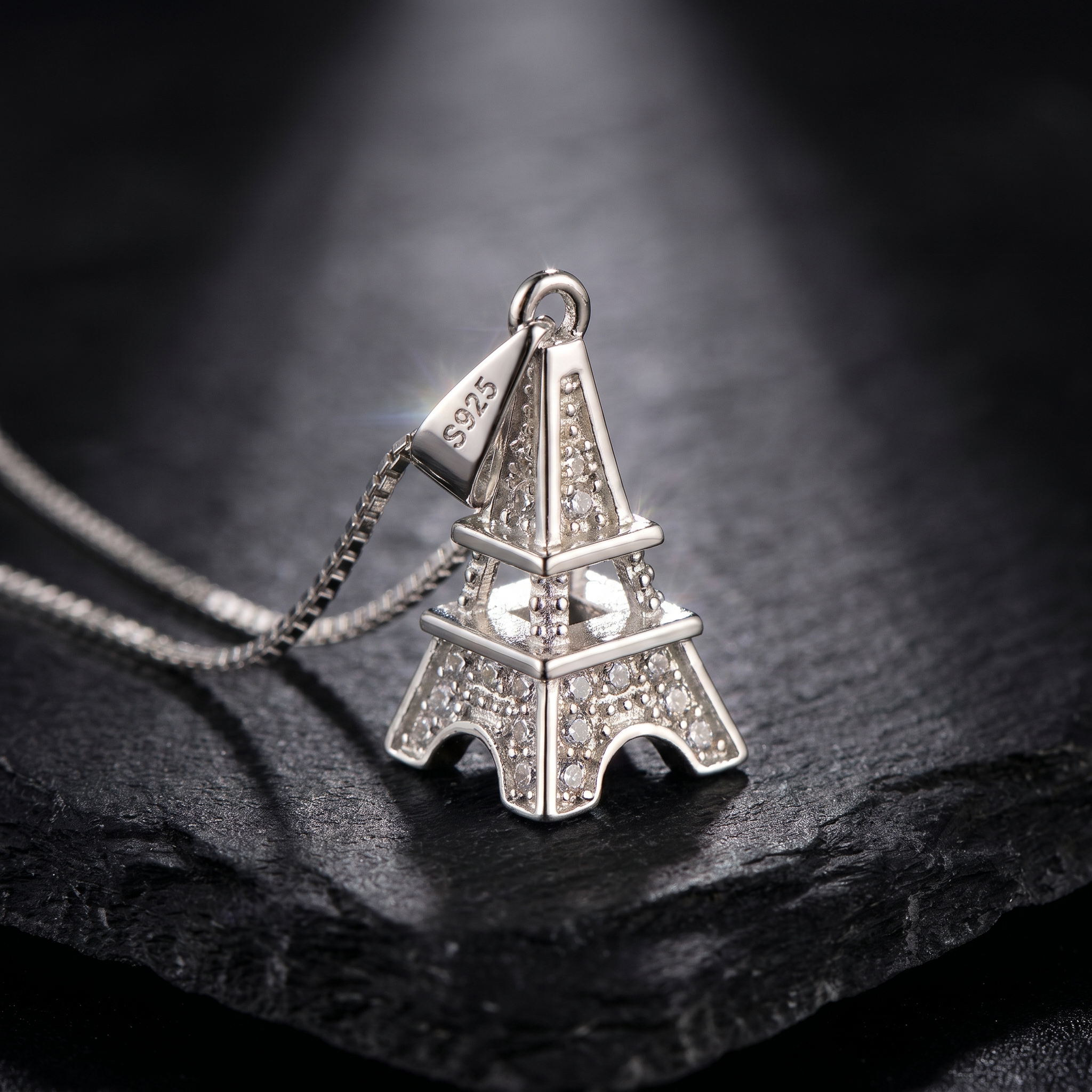 Luxury 925 Sterling Silver Eiffel Tower Pendant Necklace featuring pavé zirconia crystals, visible S925 hallmark, and elegant box chain showcased on a premium black stone background.