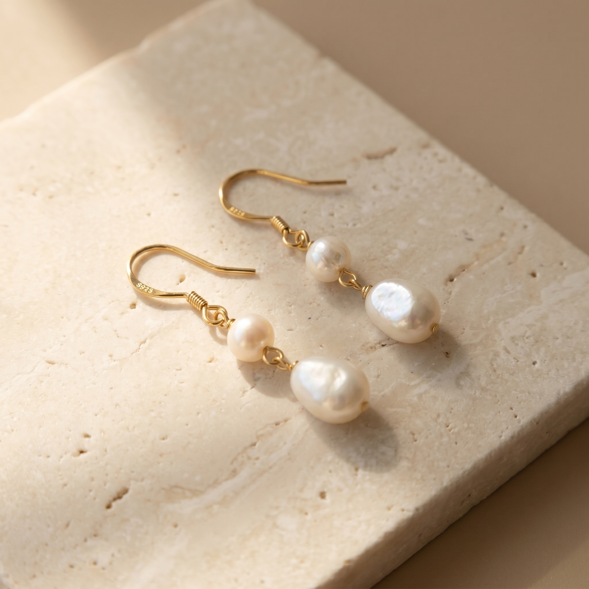 Freshwater baroque pearl drop earrings on ivory stone surface