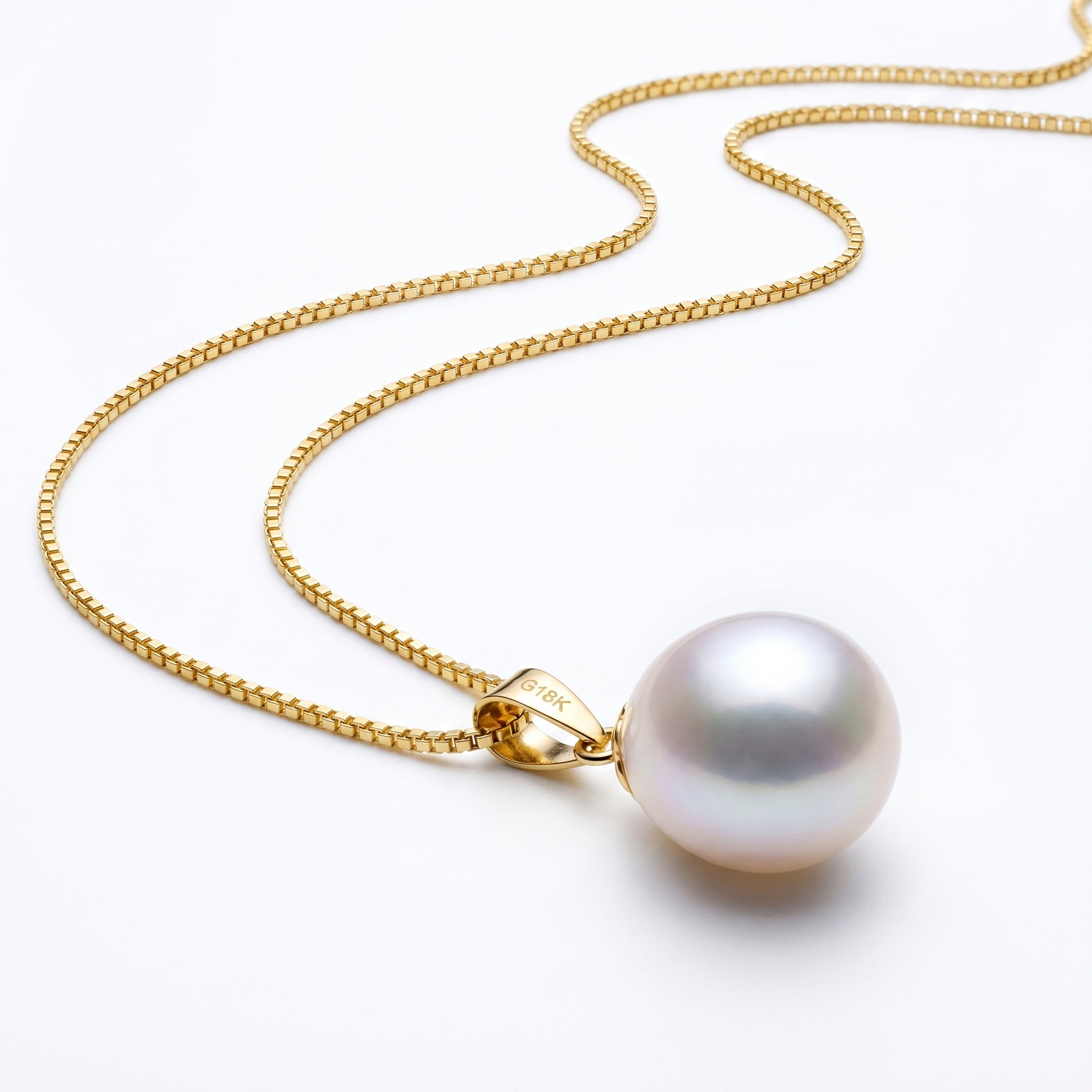Close-up of fine 18K gold plated box chain with freshwater pearl pendant.