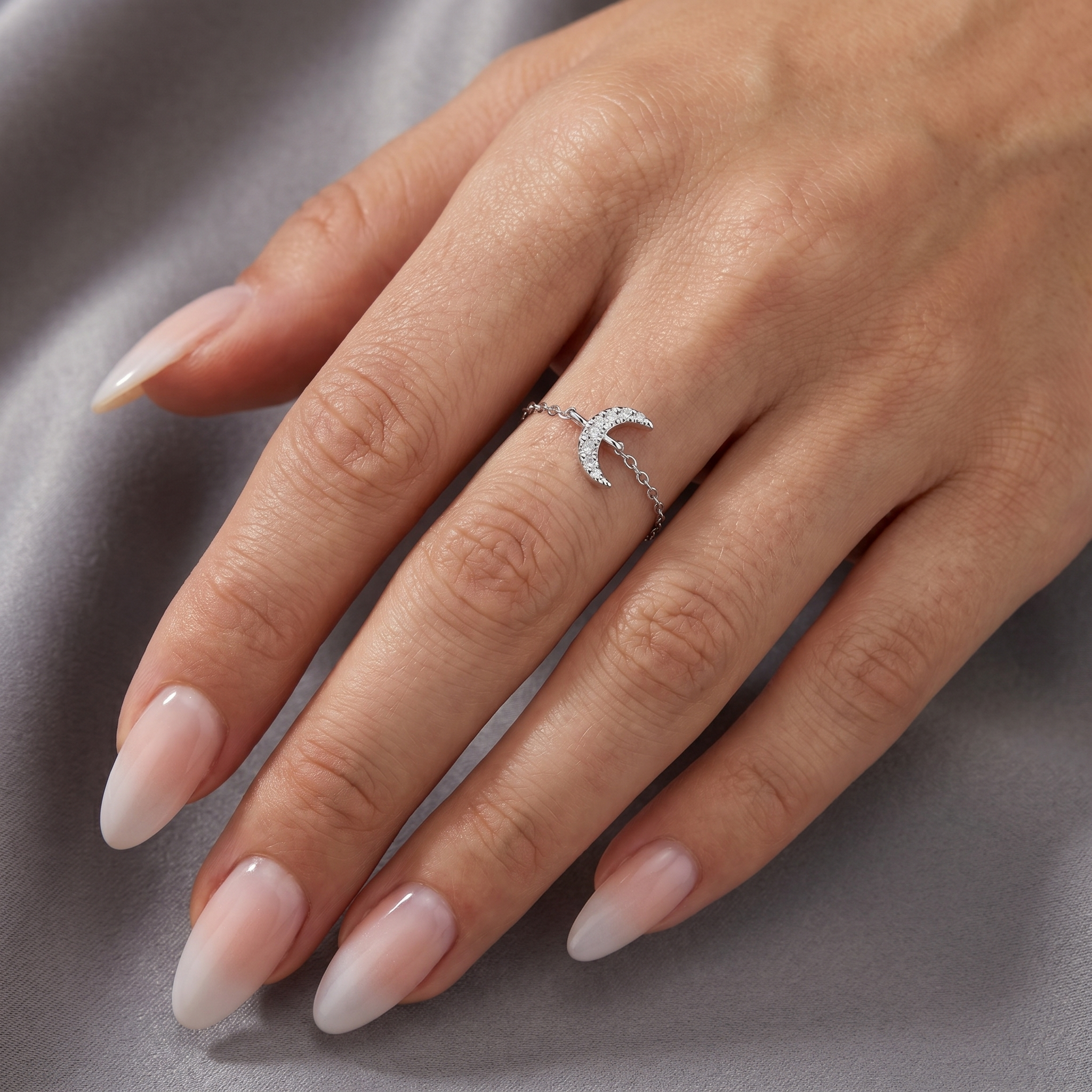 Model wearing a dainty 925 sterling silver crescent moon ring with sparkling zirconia stones and adjustable chain band.