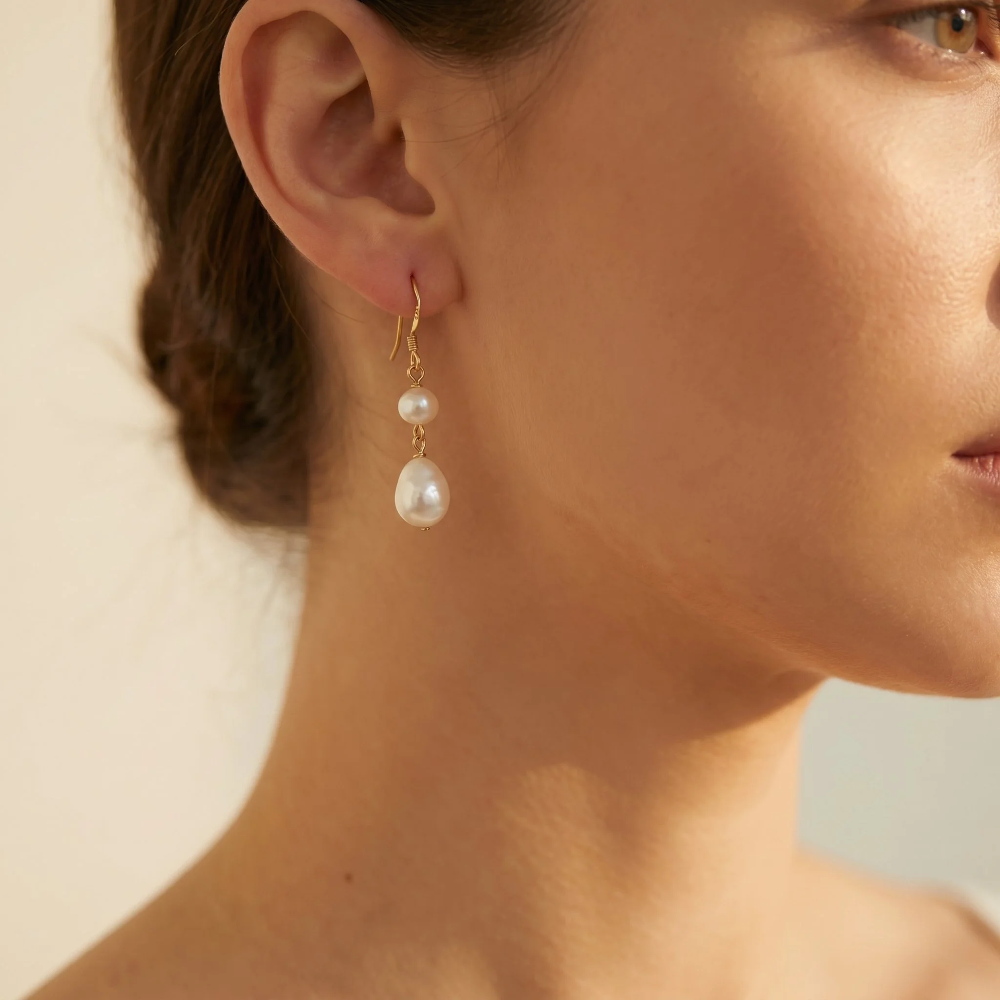 Woman wearing Lore gold freshwater pearl drop earrings