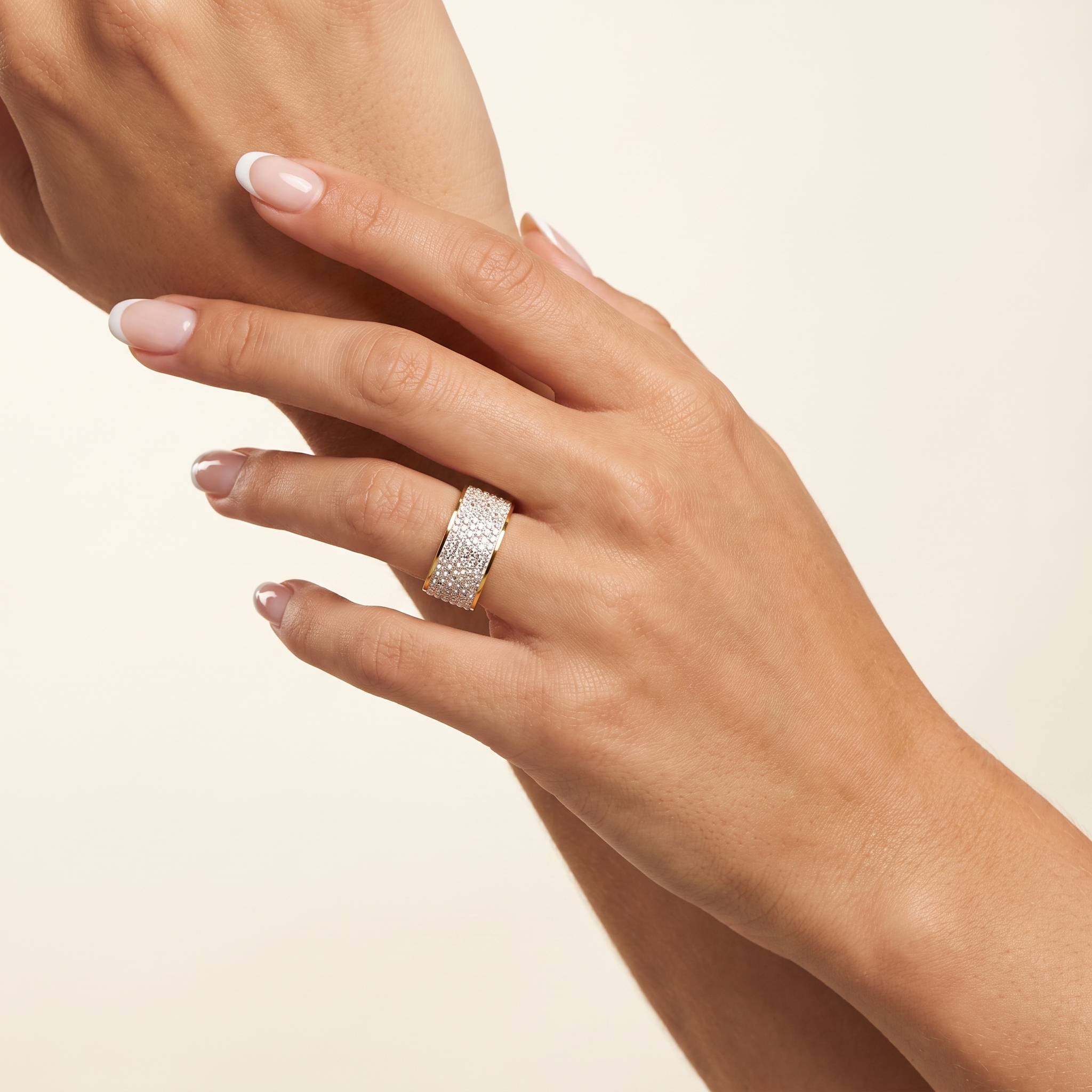 Close-up of Intensity waterproof gold pavé ring on hand, featuring clear cubic zirconia and a 12 mm wide stainless steel band