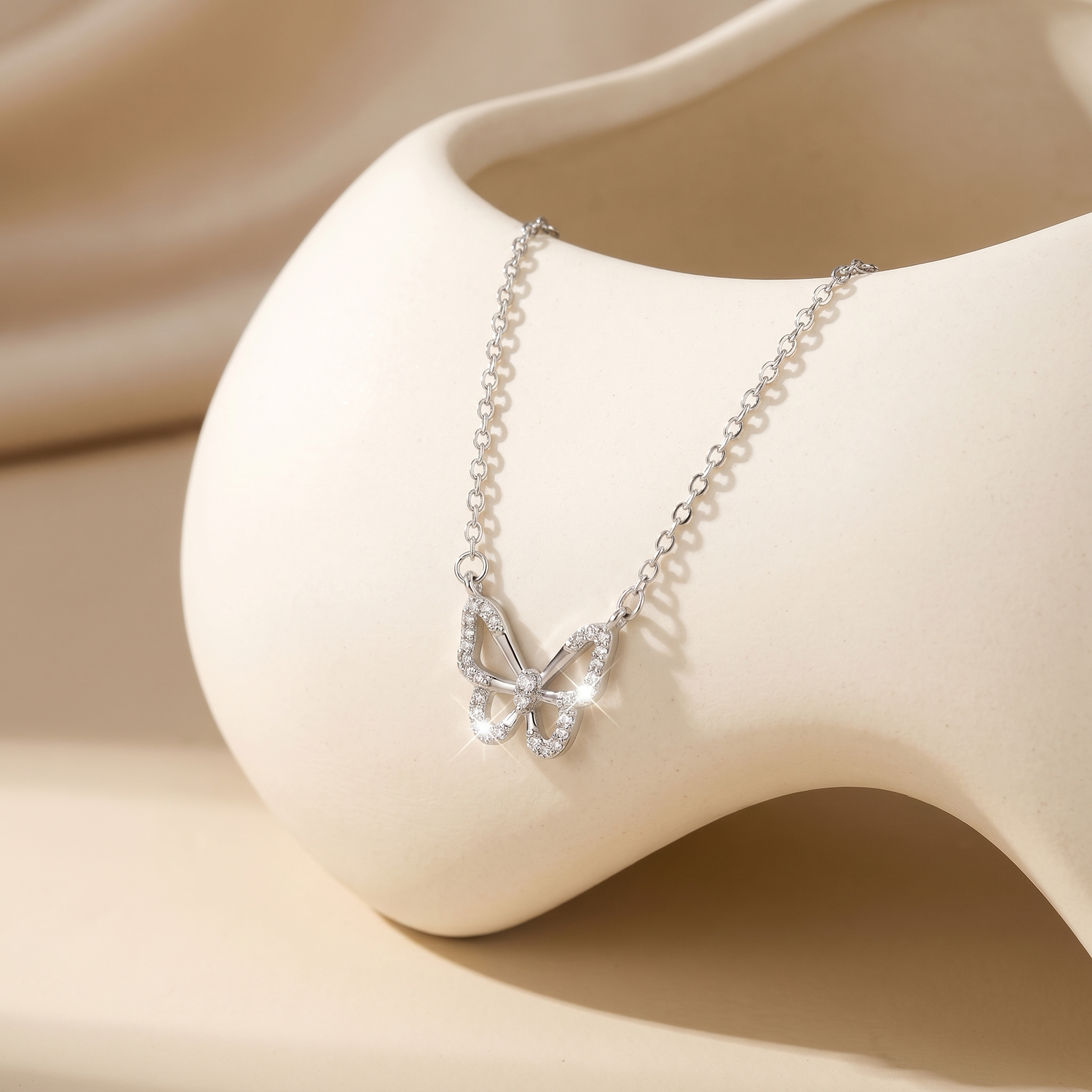 Luxury 925 sterling silver butterfly necklace displayed on a sculptural jewelry stand, sparkling zirconia butterfly pendant