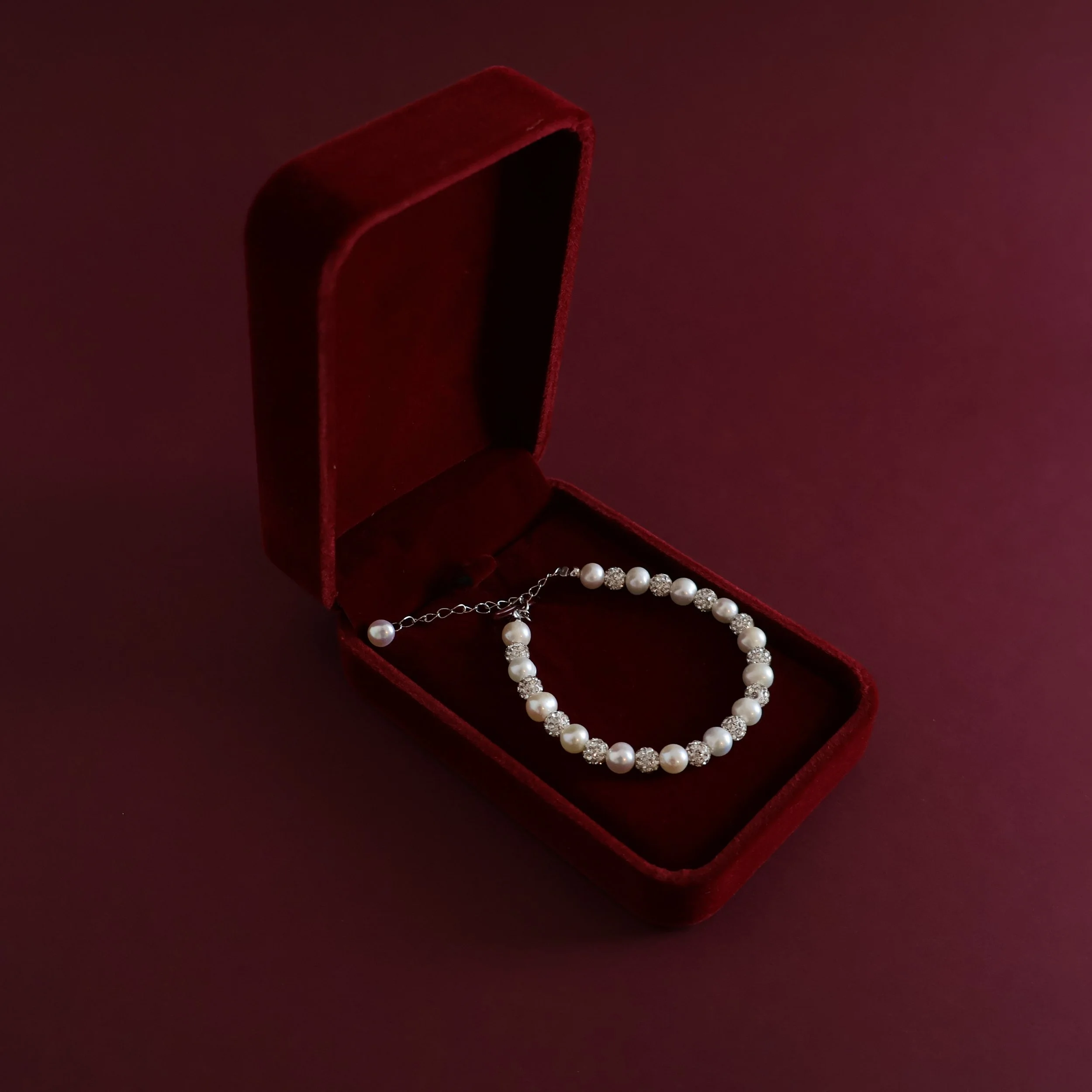 LAURRÈ white freshwater pearl and cubic zirconia silver bracelet presented in an open luxury burgundy jewellery gift box.