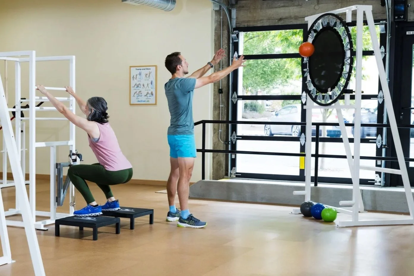 Wide shot of two ladies and a man in athletic attire working out on innovative, unique exercise equipment in a calm, well lit environment at ActiveLab gym in Vancouver, WA