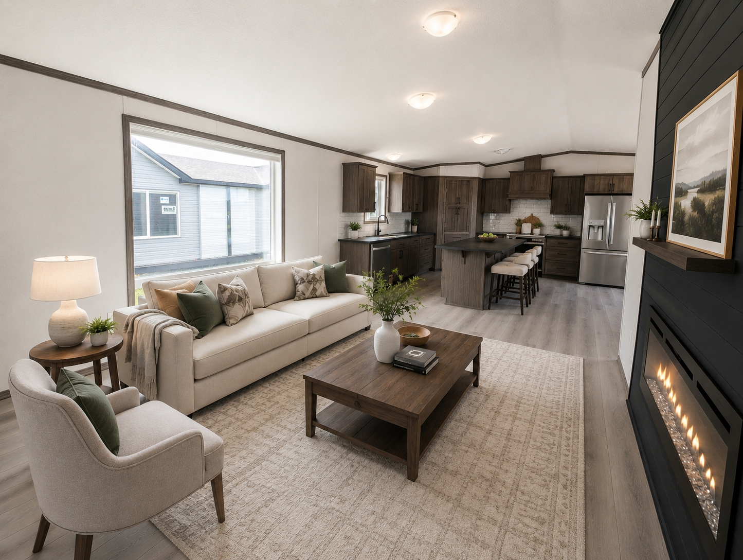Open-concept living room and kitchen with beige sofa and armchair, wooden coffee table, fireplace, and modern kitchen with dark wood cabinets, stainless steel appliances, island with barstools, and wooden flooring.