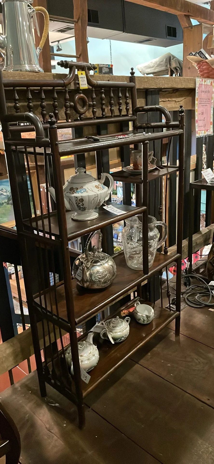 A Stick and Ball Shelf Unit with Teapots and pitchers displayed on it