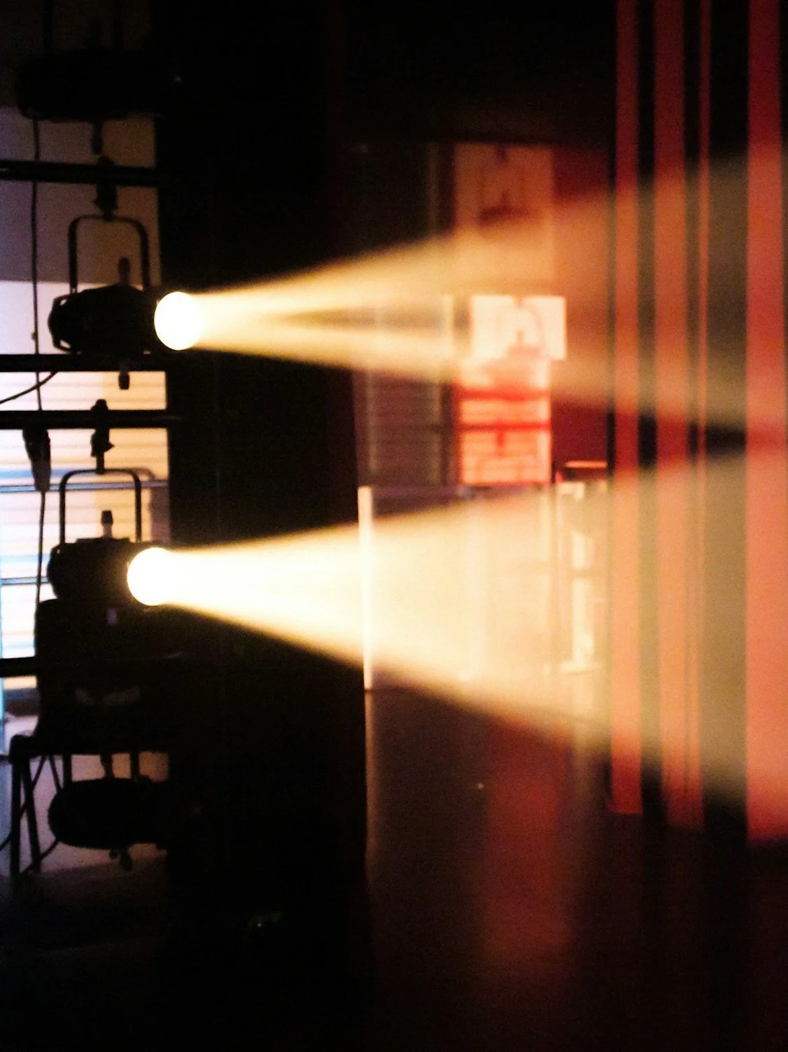 Stage lights shining beams in a dark room