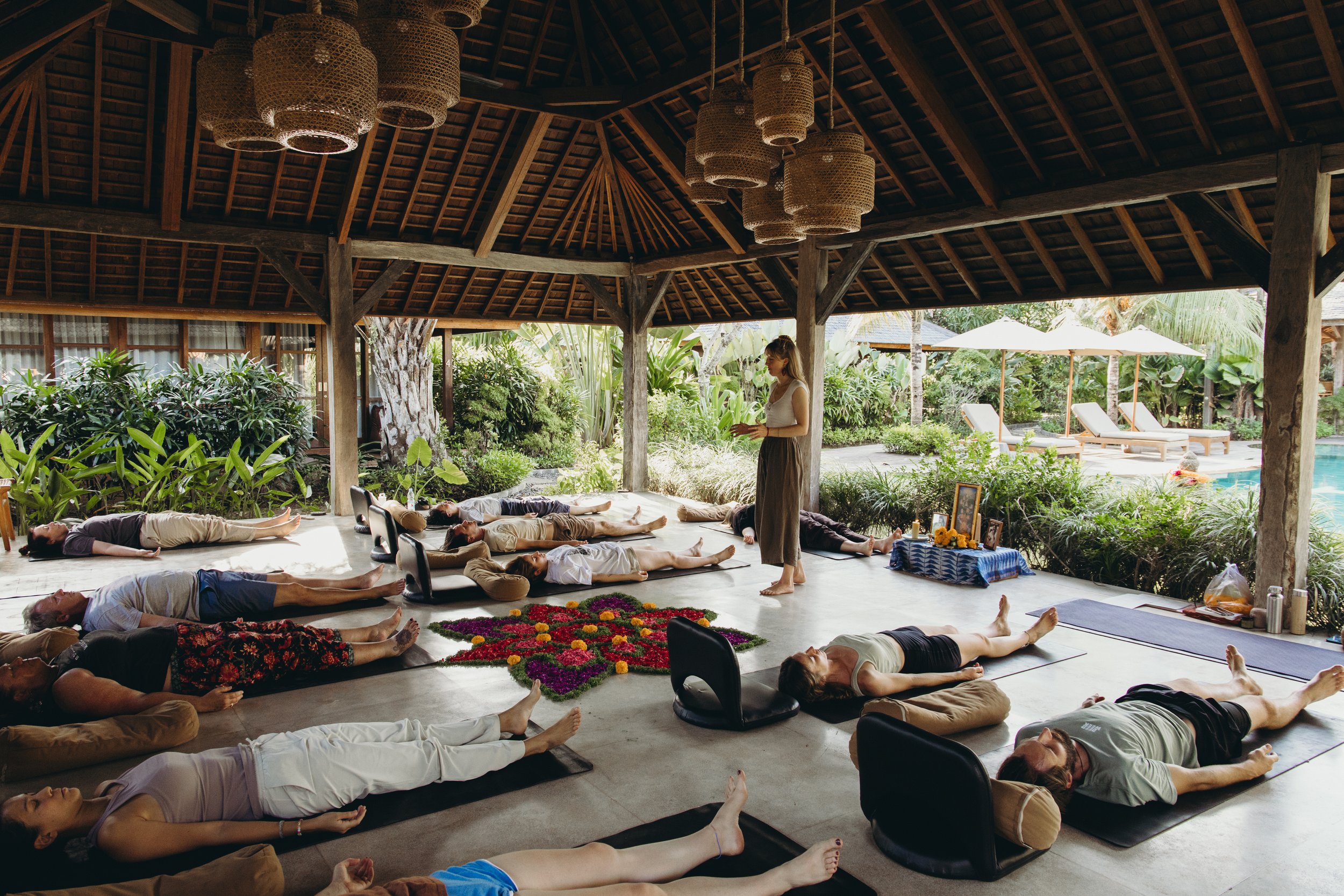 Students resting outdoors in shavasana after a rounding session.