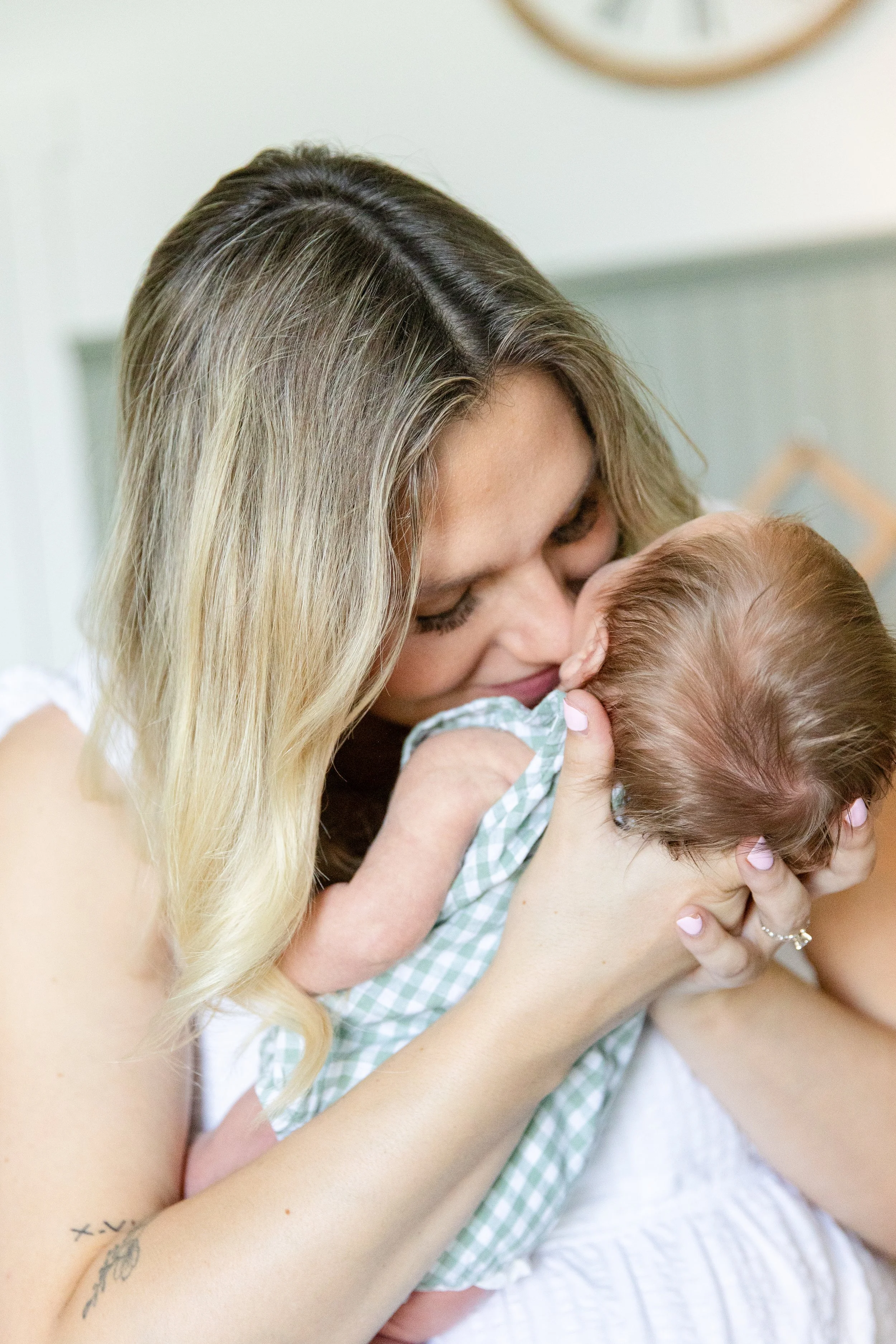 Mother snuggles baby during an in-home newborn photography session near Fort Collins, Colorado.