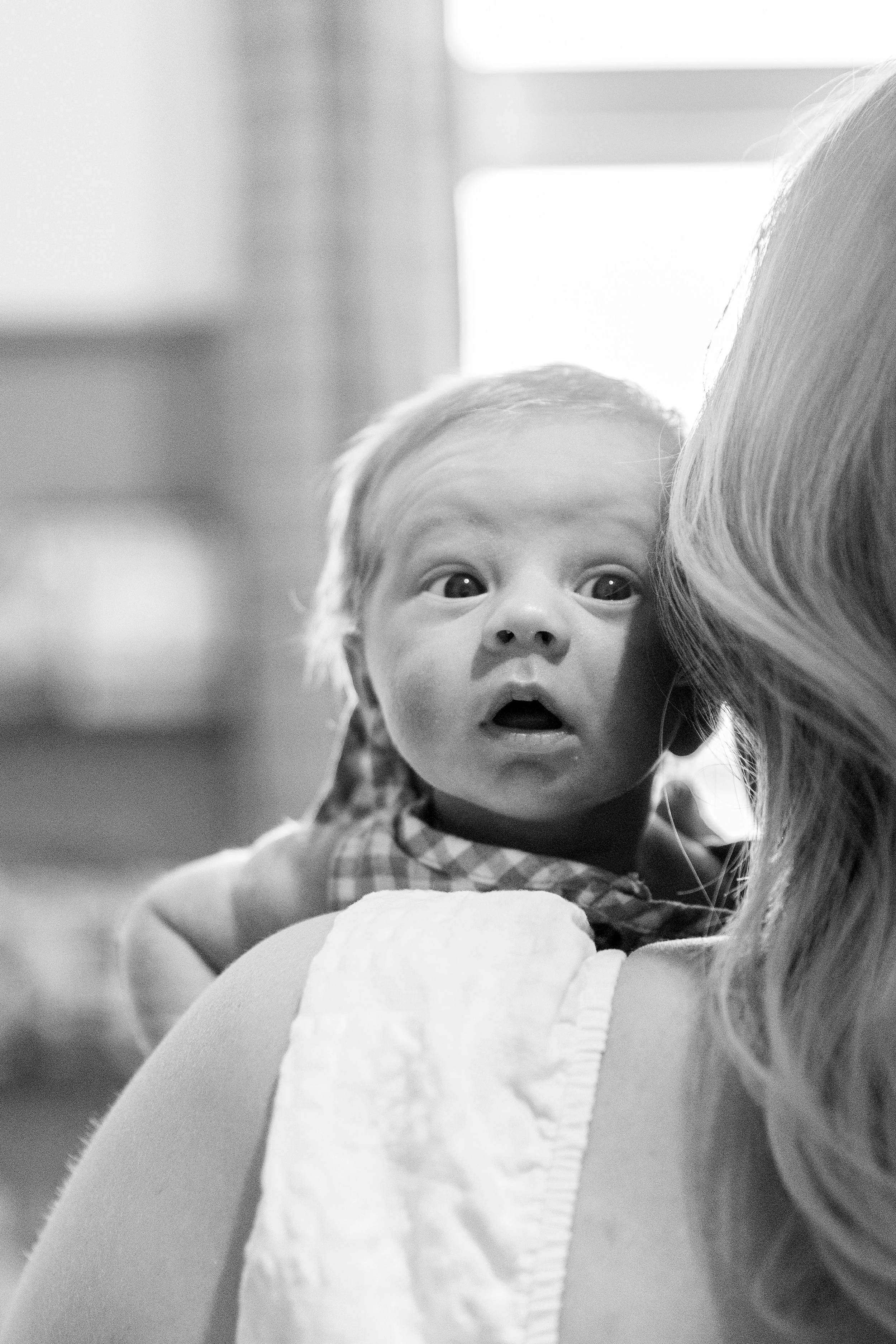 Mother holds newborn son during an in-home newborn photography session near Fort Collins, Colorado.