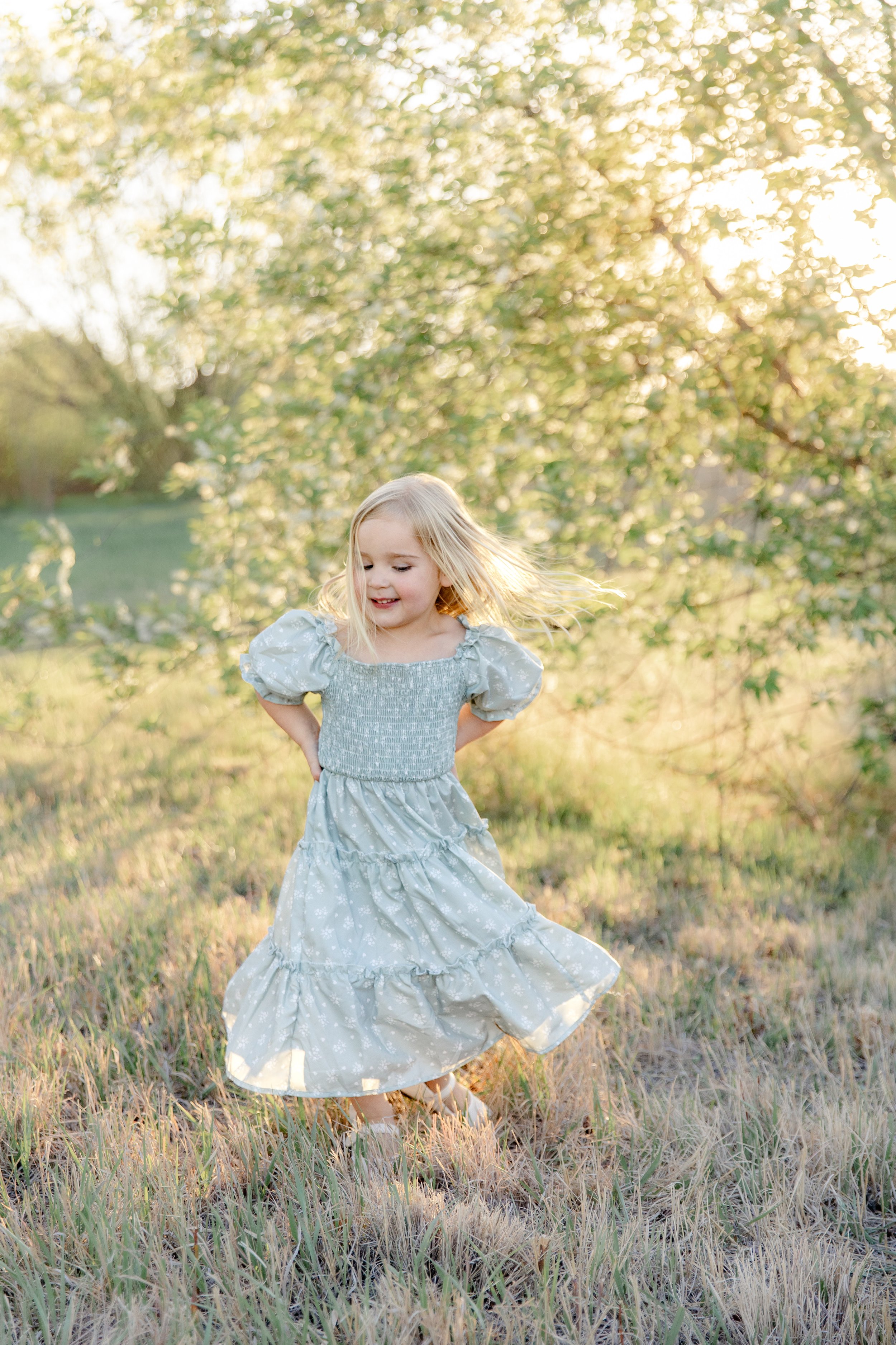Young girl twirling in dress during family photos in Fort Collins, CO