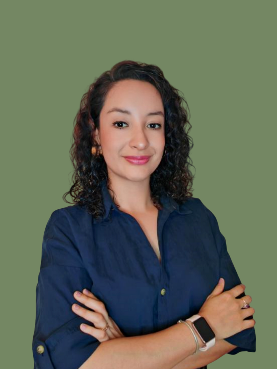 Persona de cabello rizado y gafas sonriendo, con fondo blanco.