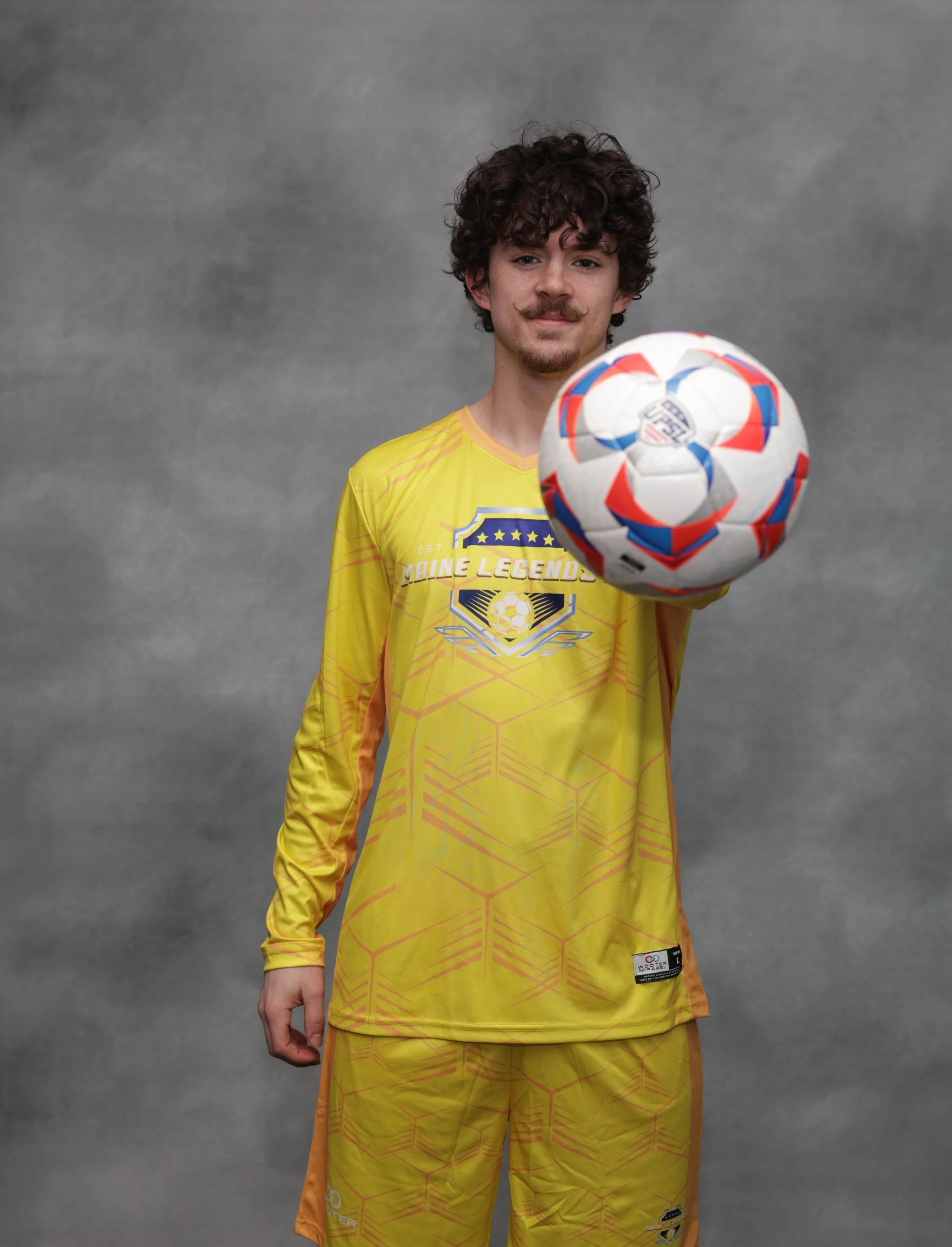 Soccer player in a blue jersey and shorts with white socks on a field.