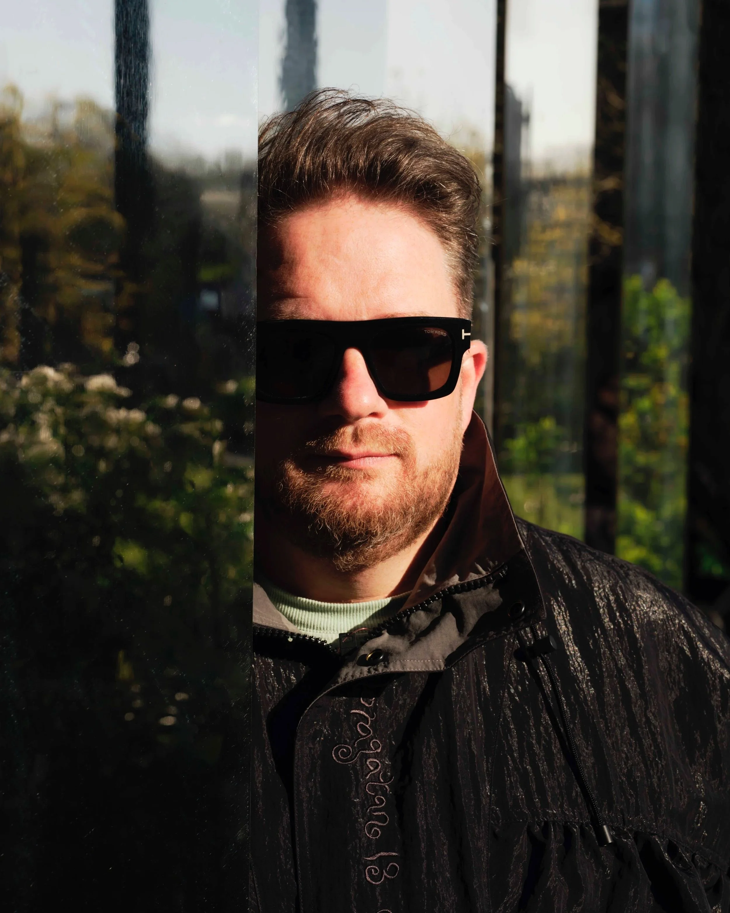 Eats Everything. A man with a beard wearing black sunglasses and a black jacket outdoors during daytime.