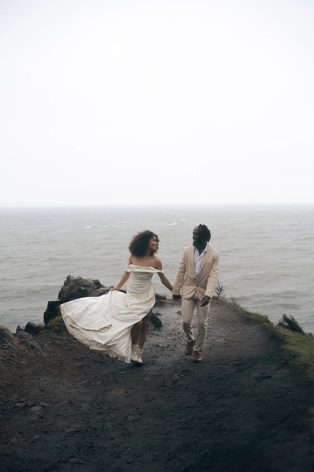 Bride and groom walking through fog and rain at Elk Flats Trail