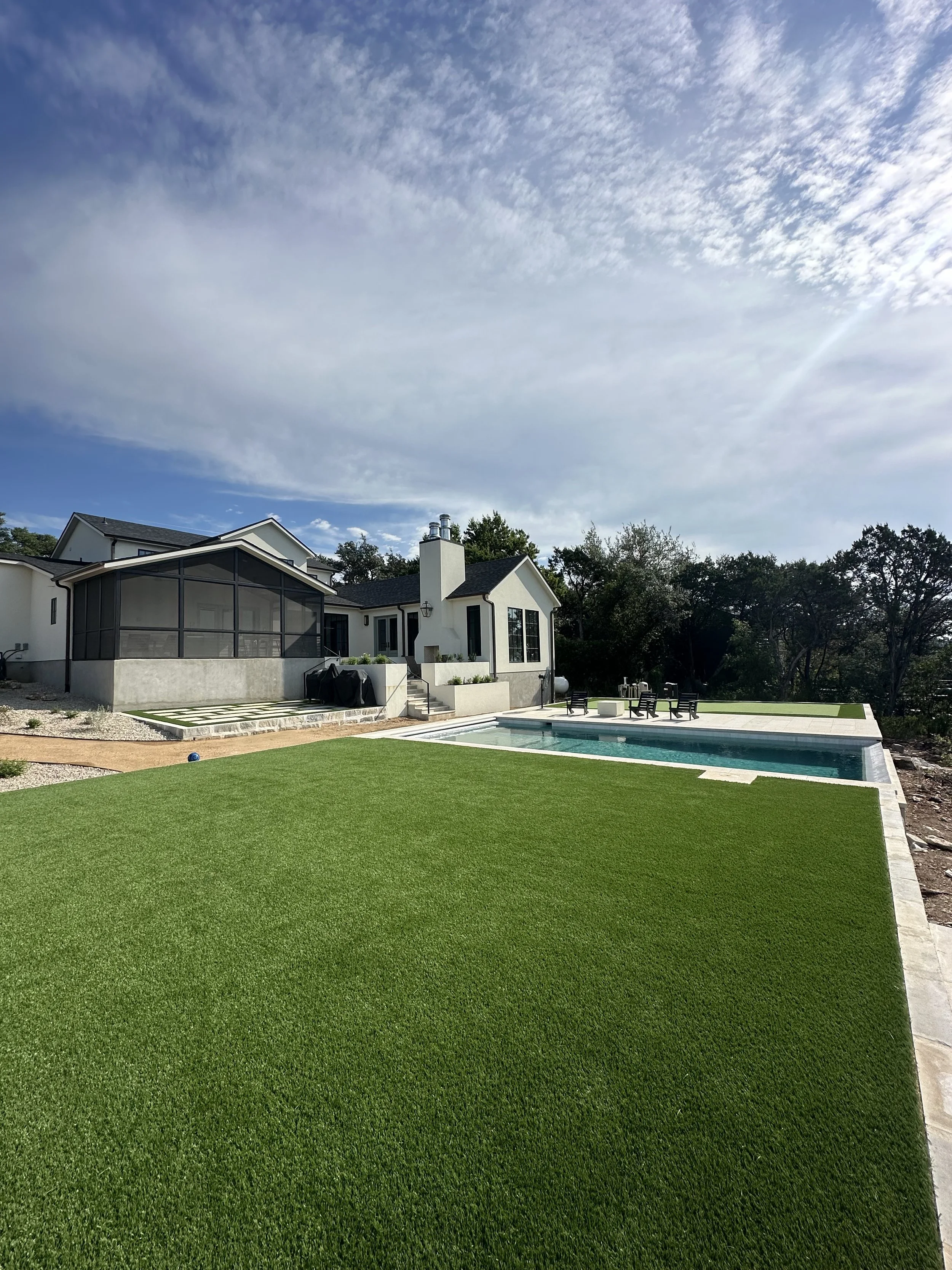 Modern backyard transformation by Golden View Landscape Design featuring a luxury swimming pool, professional synthetic turf installation, and a custom stone patio.