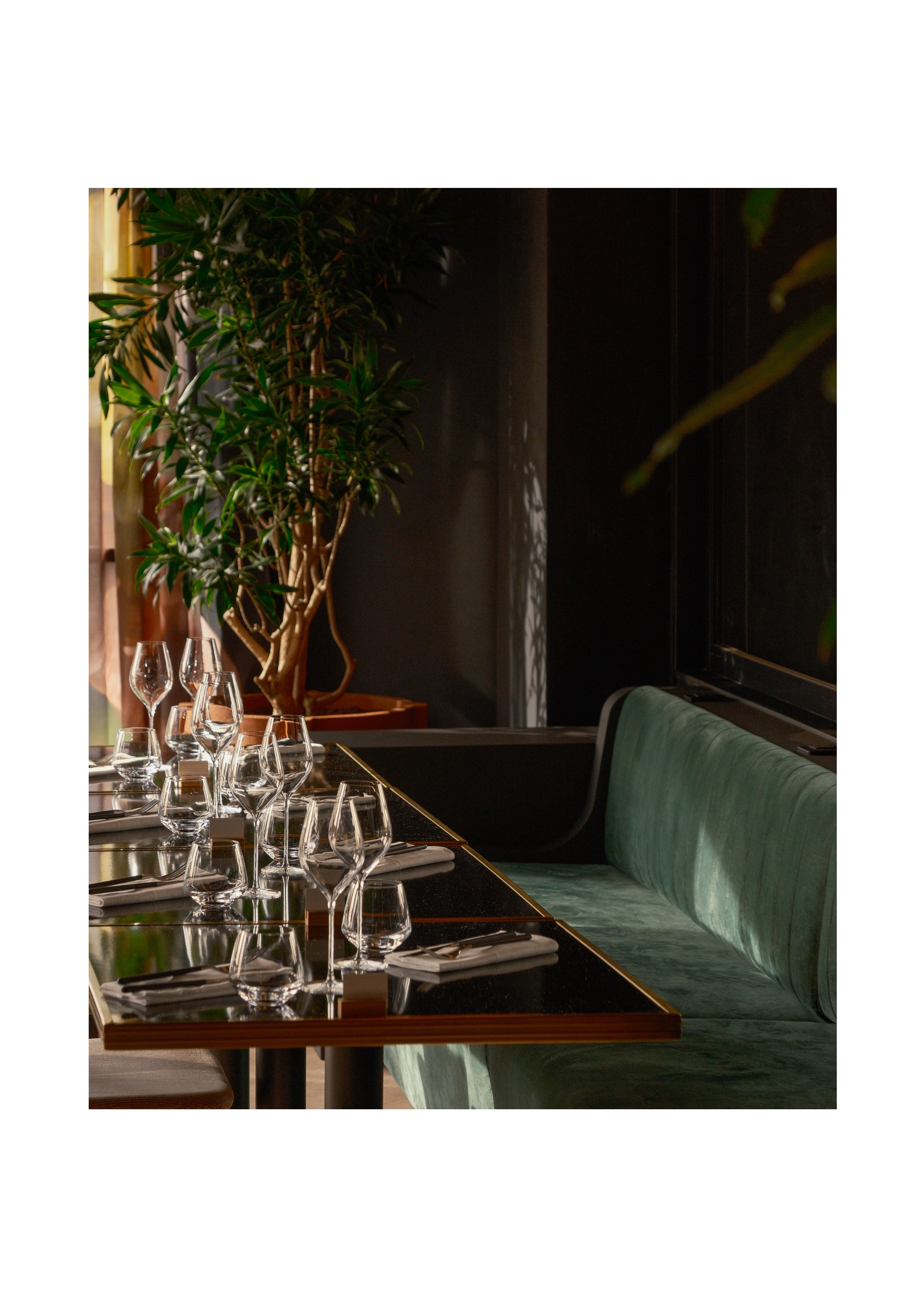 Side view of a set table with green velvet seating, modern luxury interior design at Hyatt Centric.
