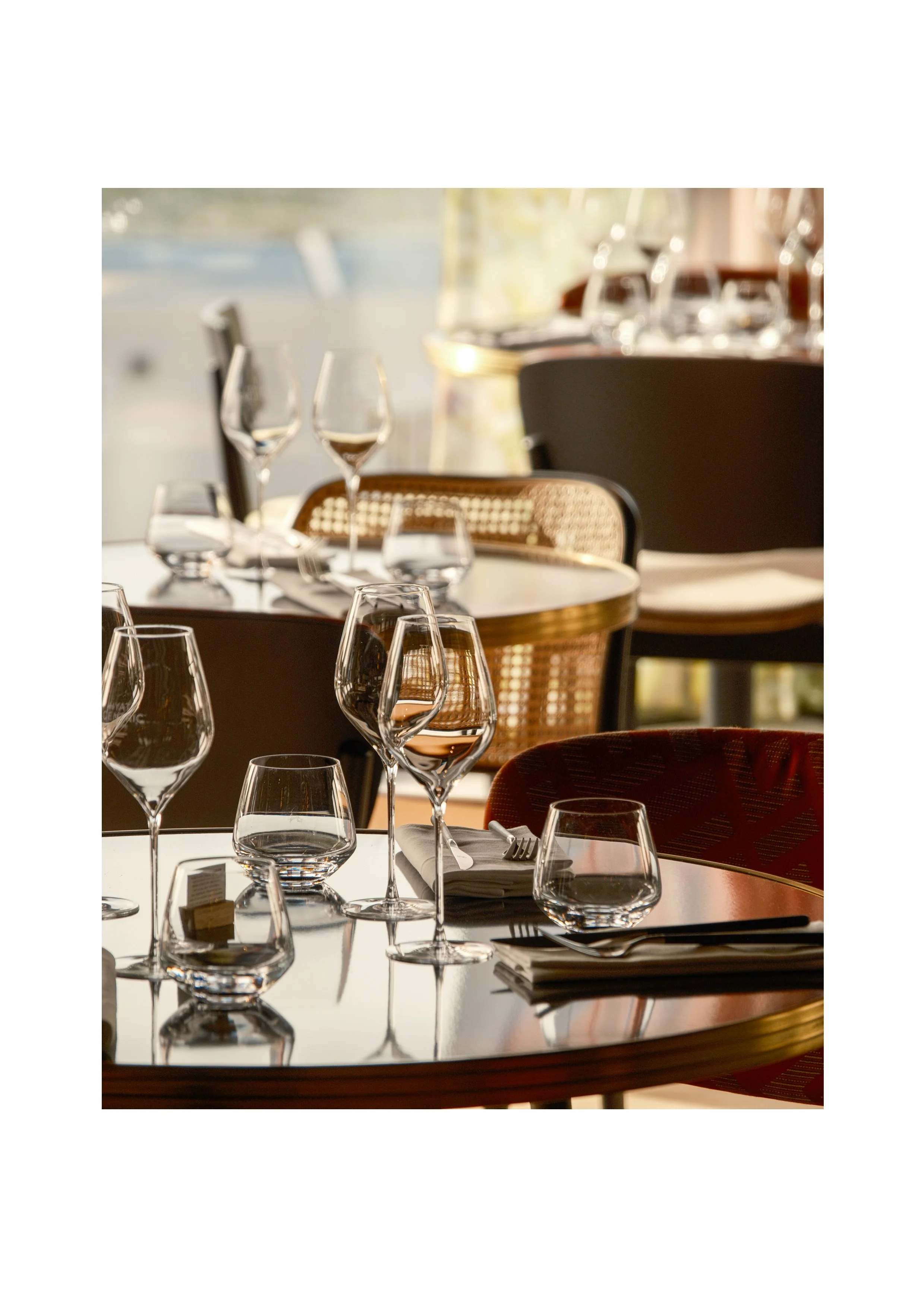 Elegant wine glasses on a restaurant table at Hyatt Centric Reims, lifestyle photography capturing the ambient golden hour light.