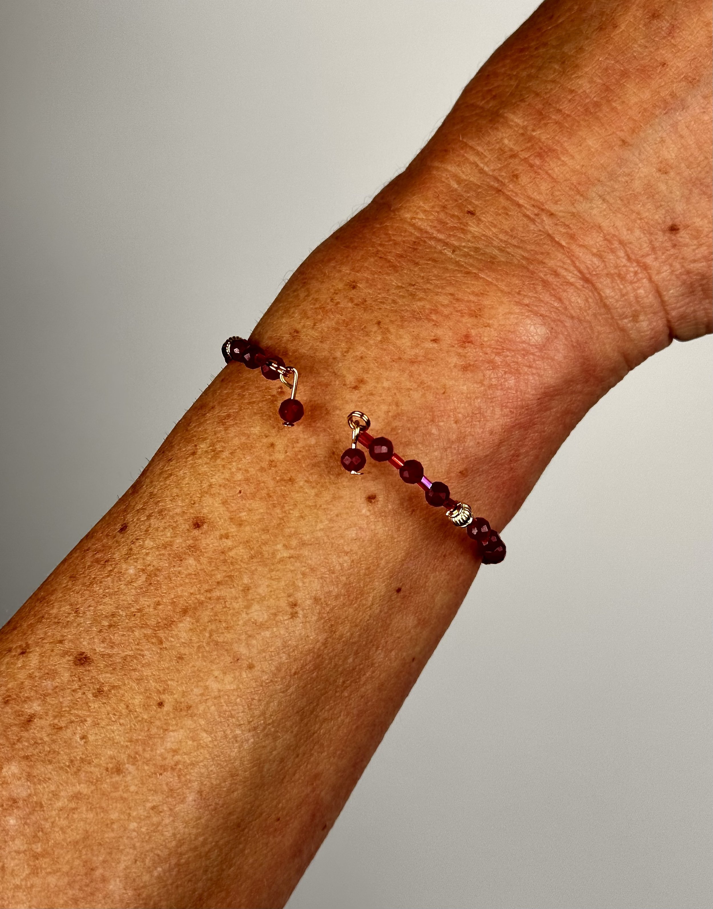 worn back view of open red berry bracelet
