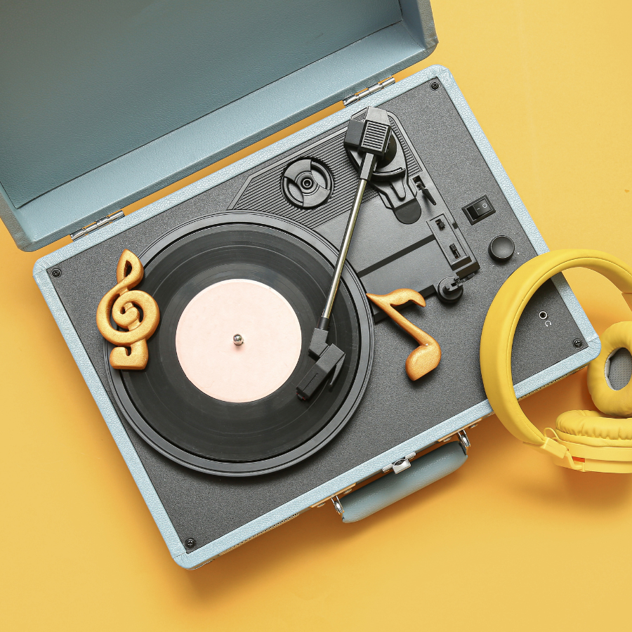 A vintage record player with yellow headphones and musical note decorations on a yellow background.