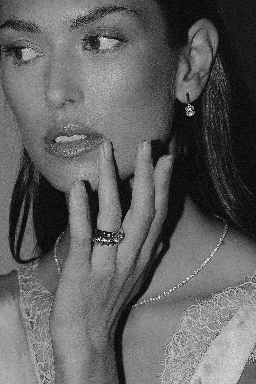 Schwarz-Weiß-Foto einer Frau, die Schmuck trägt, inklusive Ringe, Ohrringe und Halskette.