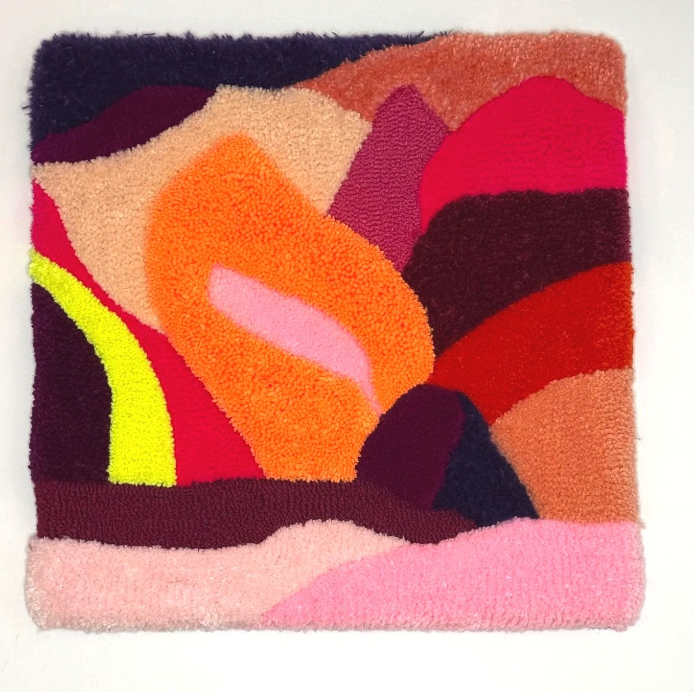 Colorful abstract patterned textile, featuring curved shapes in shades of orange, pink, red, yellow, purple, black, beige, and brown.