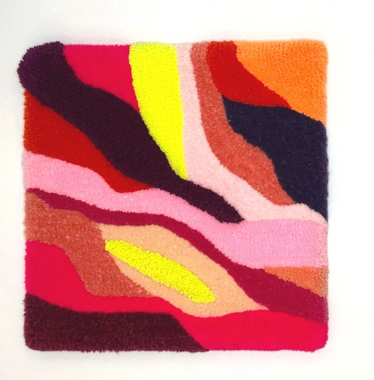 Abstract multicolored rug with pink, red, orange, yellow, black, and brown wavy patterns.