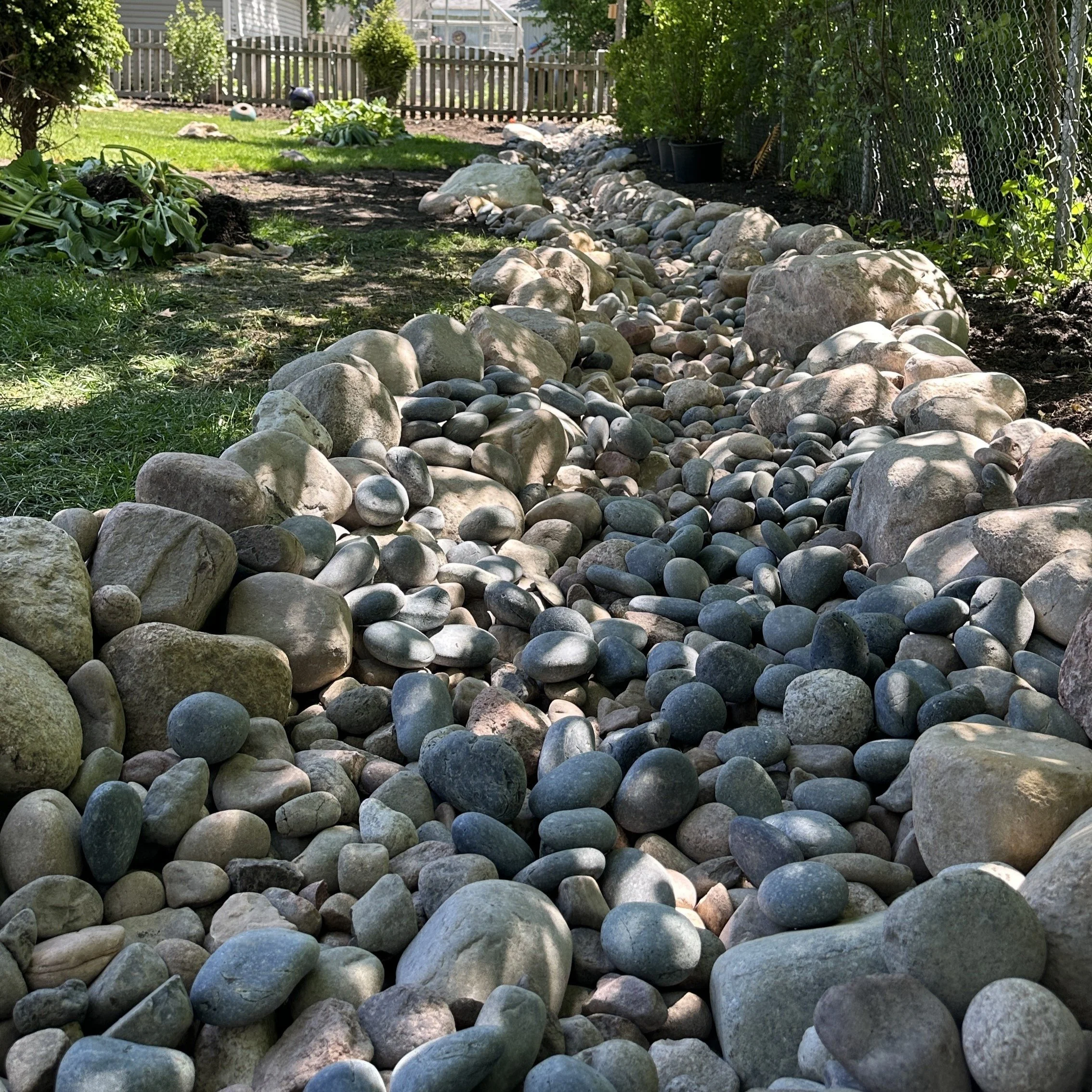 dry streambed with granite cobbles and boulders for drainage purposes