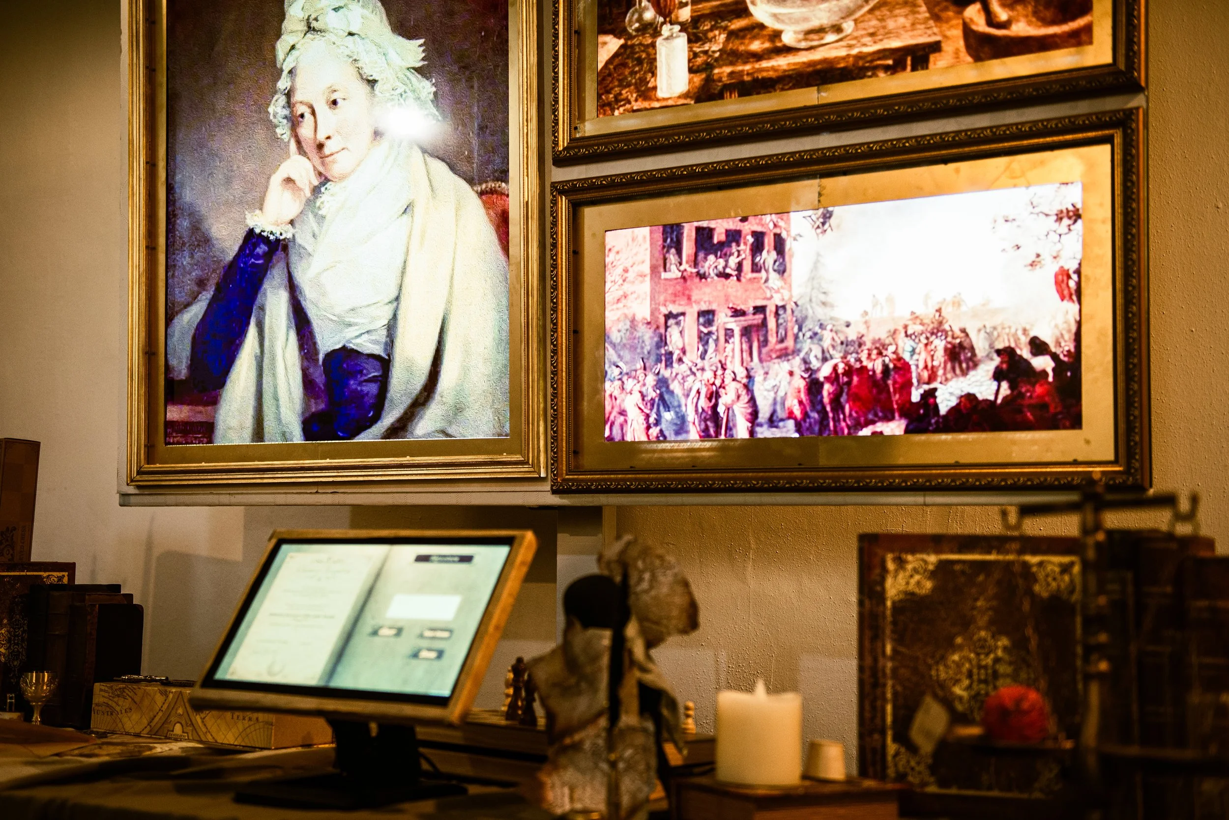Photo shows the GhAIst experience, including the touchscreen journal, the decorated desk with props, and the three framed screens on the wall with memories from Priestley's life. Source: GhAIst Team.
