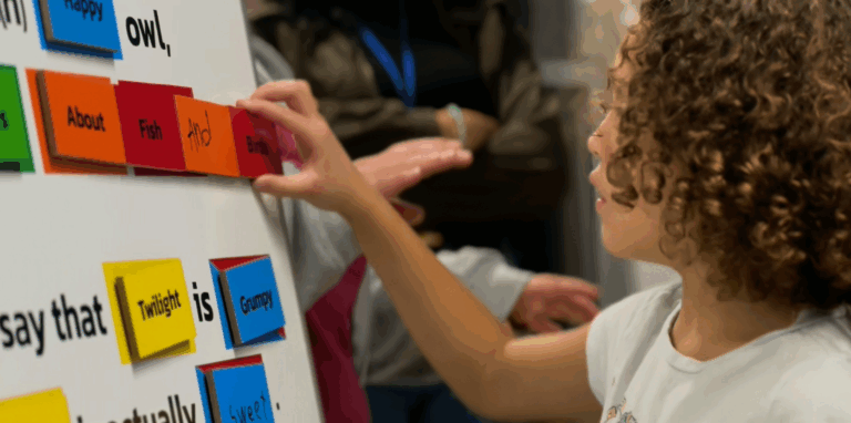 Close-up photo of a student creating a story using cards with words. Photo Credit: Little Owl Construction Co.