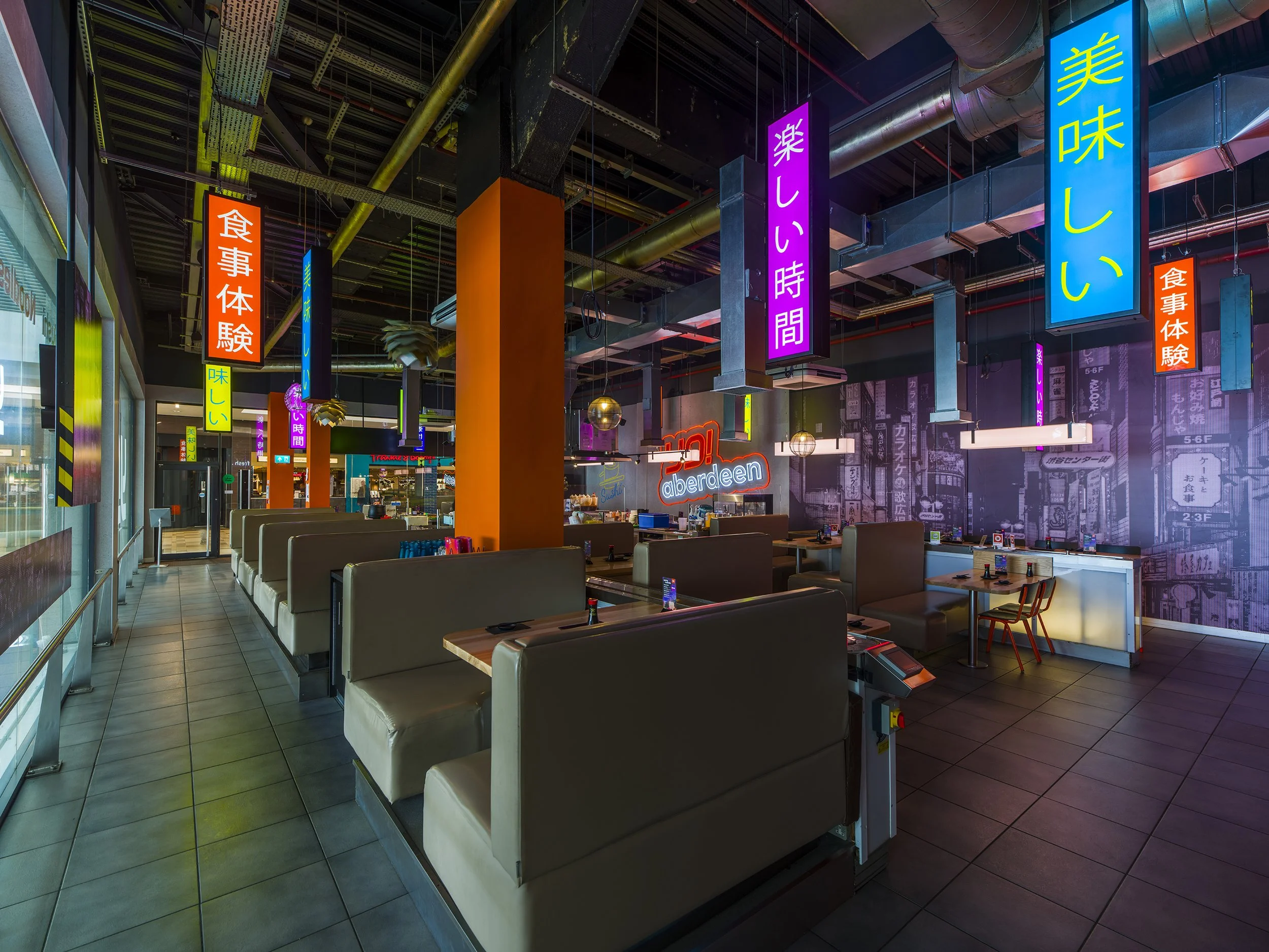 Modern sushi bar with illuminated seating, timber countertops, and vibrant Japanese-inspired decor at YO! Aberdeen.