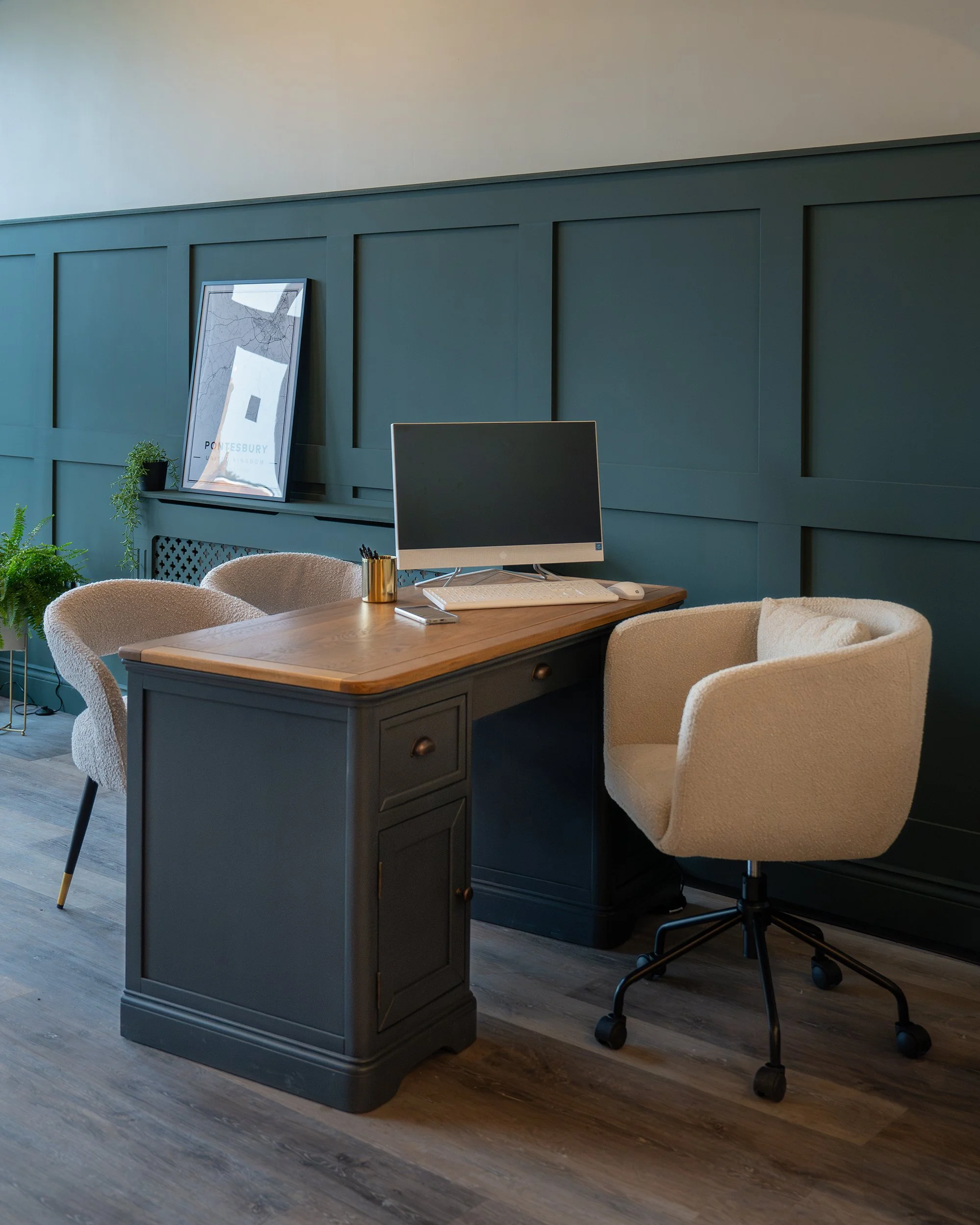Contemporary workspace at Grantham's Estates featuring bespoke desk design, soft neutral seating, and sophisticated dark green interior styling.
