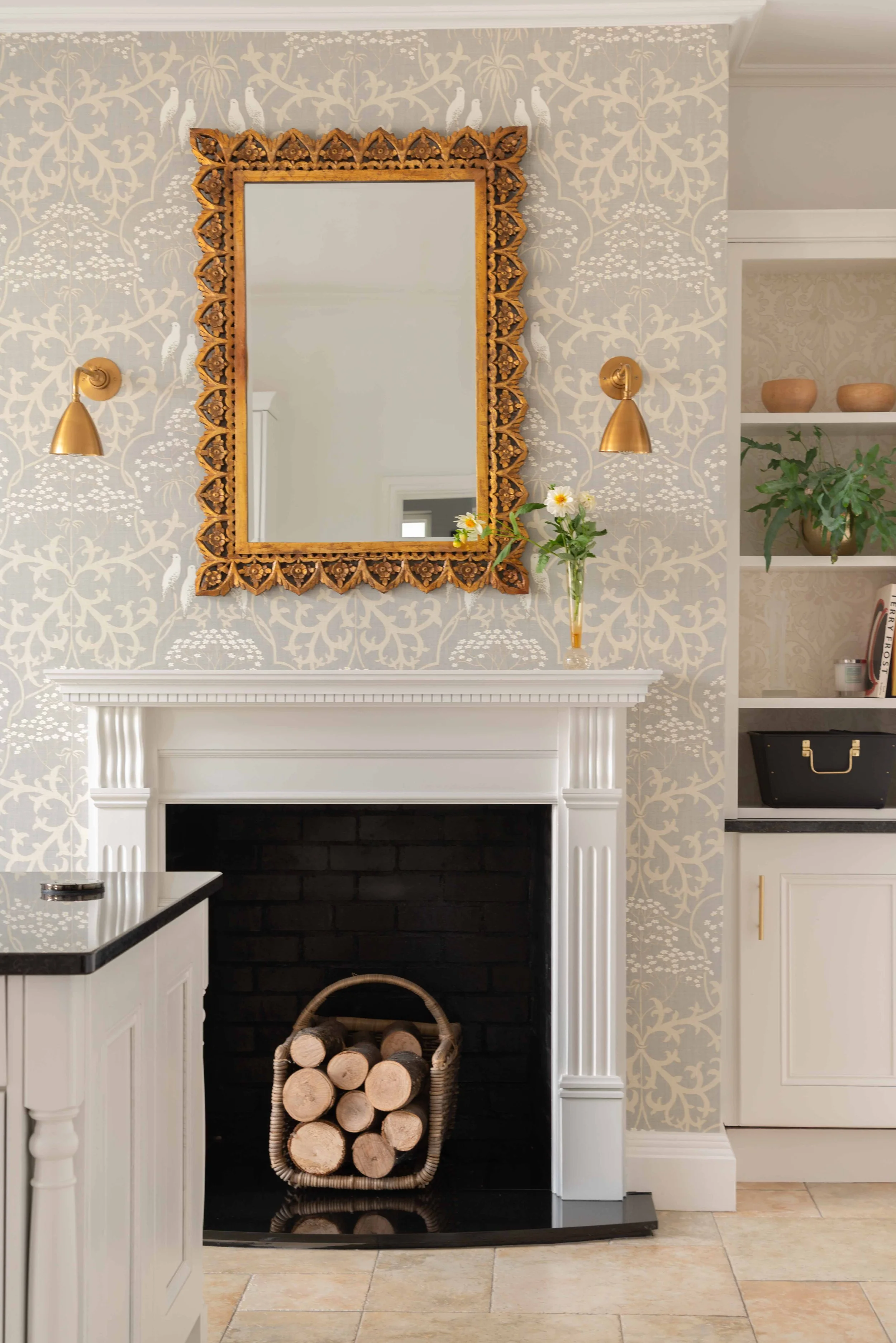 Elegant Georgian country home fireplace with ornate gold mirror, brass wall lights, and soft neutral wallpaper blending heritage charm with timeless design.